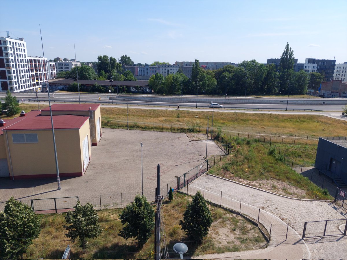 rutkiewicz_pawe's tweet photo. Hałas upałów.

To budynek PKP Energetyka, w którym znajdują się instalacje tunelu @Miasto_Lodz z Łodzi Fabrycznej w kierunku Warszawy. Mieszkam w jego sąsiedztwie 5 lat i chyba nigdy go nie słyszałem. Aż do ostatniego weekendu.

Ekstremalne upały powodują, że chłodzenie instalacji wychodzi z siebie, a efektem jest hałas - jak przy trasie szynkiego ruchu.

Nie mierzyłem decybeli, ale na pewno jest to stężenie dźwięku przekraczające poziom dozwolony w przestrzeni mieszkalnej. Okien otworzyć się praktycznie nie da - nawet w nocy, kiedy już by się chciało. W piątek budynek wył do do 22, w sobotę do 2 w nocy, wczoraj do północy.

Jeżeli sytuacja będzie ciągła trzeba będzie pewnie skrzyknąć sąsiedzką samopoc na rzecz wytłumienia budynku (o ile to możliwe). Ale zastanawiam się, czy najprostszym rozwiązaniem na przyszłość nie jest... posadzenie drzew. Bo że drzewa obniżają latem temperaturę wiadomo nie od dziś.

Miejsce jest na pustej działce po północnej stronie budynku, wzdłuż al. Grohmanów (widac na zdjęciu z góry). Kiedyś próbę zresztą podjęto. Posadzono tam parę lat temu jakieś rachityczne drzewka, które nigdy nie wyszły poza stadium patyka.