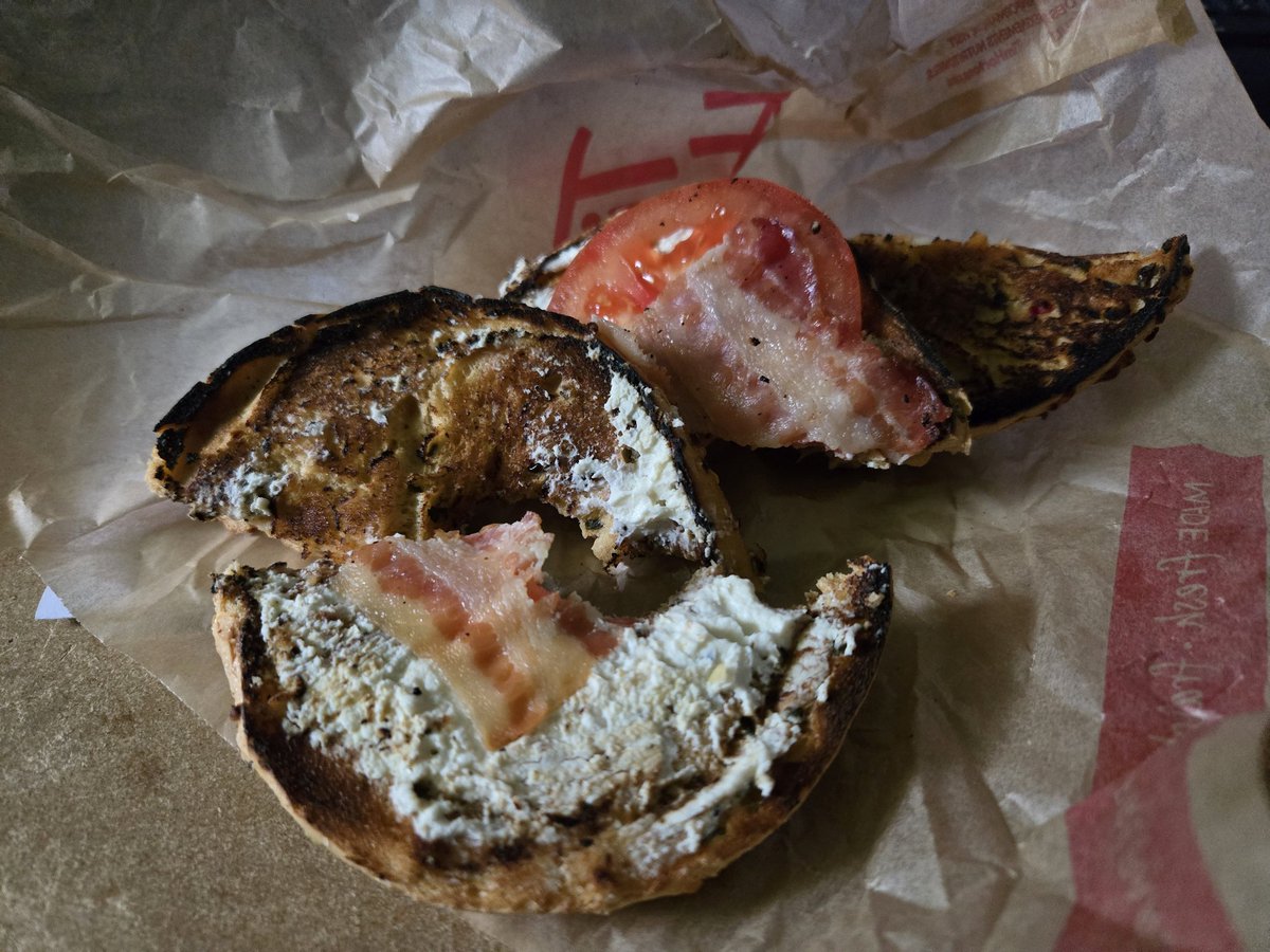 AllinaGeneraton's tweet photo. What a sad example of a bagel from Tim Hortons in southern Ontario. This is supposedly a 'Toasted,   Cream Cheese, Tomato and Bacon'. Virtually no cream cheese, 2 tiny 'gold film thin' pieces of bacon, 1 thin slice of tomato. And a burnt bagel.  I can't wait for Dunkin Donuts. Please hurry...