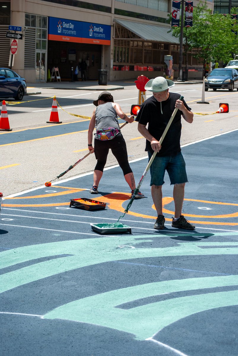 DowntownCLE's tweet photo. Downtown is heating up, and not just from the weather!🔥The Gateway District’s new asphalt mural is officially underway on Huron Rd, adding some sizzling new color to the neighborhood!🎨

Artist Ryan Jaenke and his team of professional artists are working hard on installation. https://t.co/LuVCoCScmC