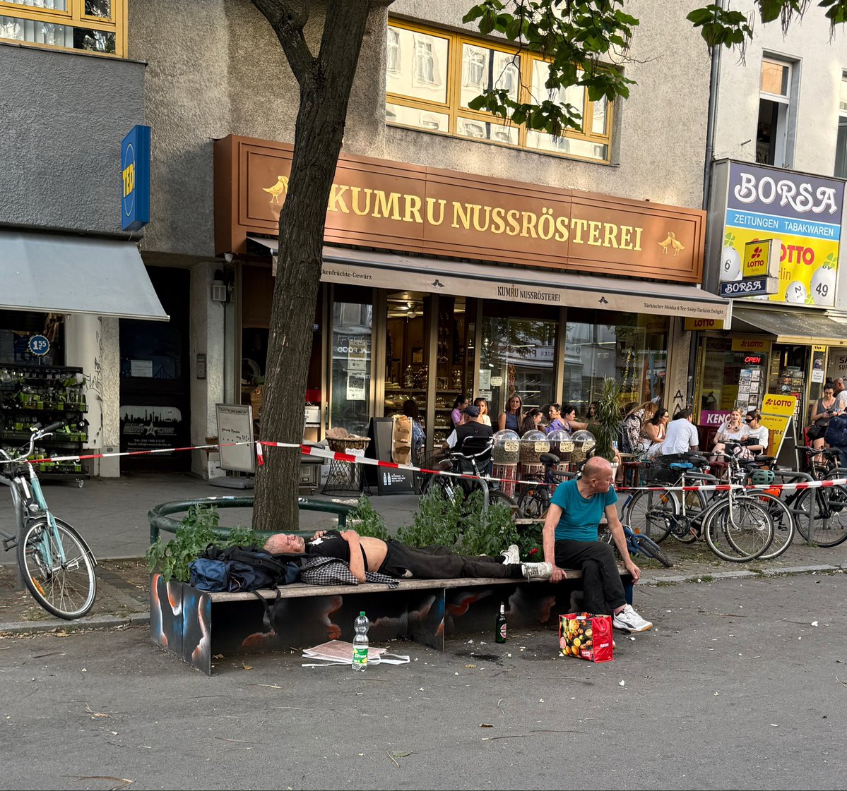 JulianAdrat's tweet photo. Wilmersdorfer Straße in Berlin Charlottenburg. Alles nur noch Fassade. Mit wenigen Meter Abstand verteilt, sitzen Menschen im Café, knabbern Nüsse neben Heroinkochern, singen Straßenmusiker neben verschleierten 7-Jährigen, bedrängen NGO-Söldner Passanten für Unterschriften für Tierschutz. Ein einzig künstlich erzeugter Verdrängungsakt, den das „Sondervermögen“ des Altparteienkartells aufrecht erhält. Aufwachen!