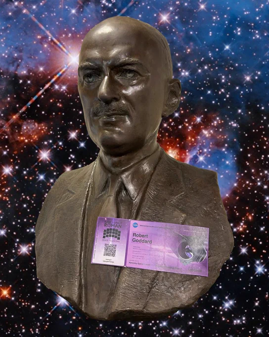 A bust of Robert Goddard, cast in a bronze color. He has a purple Roman boarding pass attached to his lapel. He is superimposed on a Hubble image of spiral galaxy NGC 3596. The galaxy’s center appears as a bright white spot surrounded by a golden glow. Two spiral arms extend out from the center, wrapping around the galaxy and broadening out to form the thick outer edge of the disk. Thin reddish strands of dust and bright pink spots follow the arms through the disk. Faint strands of stars extend from the tips of the spiral arms and out beyond the disk.