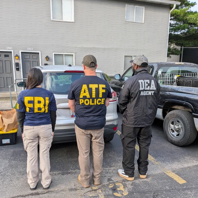 FBI, ATF and DEA agents in front of a building