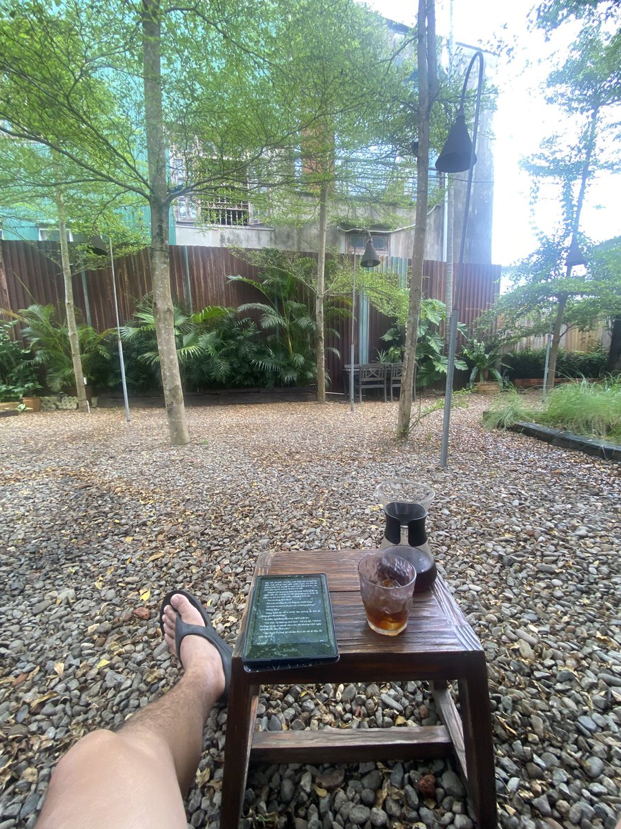 OceanLee365's tweet photo. Có người đi để ngắm cảnh. Có người đi để ăn những món ngon. Còn mình, chuyến đi này bắt đầu bằng một câu hỏi rất đơn giản: “Ở vùng đất này, người ta uống cà phê như thế nào?”

Bốn ngày từ Hà Nội đến Hội An không phải là một chuyến “coffee tour” đúng nghĩa. Mình cũng không cố gắng ghé hết những quán nổi tiếng hay săn tìm những ly cà phê được chấm điểm cao. Điều mình tìm kiếm là cảm nhận được mối liên hệ giữa con người, vùng đất và ly cà phê họ đang uống.

Trong nghiên cứu về cà phê đặc sản, người ta thường nhắc đến khái niệm terroir – tập hợp những yếu tố như khí hậu, thổ nhưỡng, độ cao, giống cây và phương pháp canh tác tạo nên cá tính của hạt cà phê. Nhưng sau nhiều năm tìm hiểu, mình nhận ra rằng còn một tầng terroir khác ít được nhắc đến hơn: văn hóa.

Một ly cà phê không chỉ mang hương vị của nơi hạt cà phê được trồng, mà còn mang dấu ấn của nơi nó được pha, của người pha và của người thưởng thức.

Huế là nơi mình cảm nhận điều đó rõ rệt nhất.

Nhịp sống chậm rãi của cố đô dường như hiện diện ngay trong cách người ta pha một ly cà phê. Không cần quá nhiều kỹ thuật phô diễn, cũng chẳng cần một thực đơn cầu k��. Chỉ là một khoảng lặng vừa đủ để mùi hương lan tỏa, để người uống có thời gian nhìn dòng người qua lại, nghe tiếng những người dân địa phương trò chuyện hay cảm nhận cơn mưa bất chợt ghé qua. Ở Huế, cà phê giống như một khoảng nghỉ trong ngày hơn là một thức uống giúp tỉnh táo.

Hội An lại mang đến một sắc thái khác.

Ở đây, cà phê trở thành một phần của trải nghiệm du lịch nhưng vẫn giữ được bản sắc địa phương. Những quán nhỏ trong ngõ, những khoảng sân phủ đầy nắng hay ban công nhìn xuống mái ngói rêu phong đều có cách kể câu chuyện riêng. Điều thú vị là, dù phong cách có hiện đại đến đâu, người ta vẫn cố gắng giữ cho ly cà phê một sự gần gũi, như chính nhịp sống của phố cổ.

Thế nhưng, ly cà phê khiến mình nhớ nhất lại không đến từ bất kỳ quán nào.

Đó là chai cold brew 8RO Specialty mình tự pha từ Hà Nội.

Cold Brew là phương pháp chiết xuất bằng nước lạnh trong nhiều giờ. Cách pha này hạn chế việc kéo theo nhiều hợp chất tạo vị đắng và chát, v�� vậy cà phê thường trong trẻo hơn, ngọt hậu hơn và đặc biệt ổn định khi mang theo trong những chuyến đi dài.

Có những buổi sáng, mình chỉ cần dừng xe bên một khoảng xanh, thêm vài viên đá vào chiếc cốc nhỏ rồi rót Cold Brew ra. Không tiếng máy xay. Không tiếng hơi nước từ máy espresso. Chỉ có gió, mùi cỏ, ánh nắng đầu ngày và vị cà phê quen thuộc.

Lúc ấy mình chợt nhận ra, chất lượng của một ly cà phê không chỉ được quyết định bởi hạt cà phê hay kỹ thuật pha chế. Bối cảnh cũng là một nguyên liệu. Thiên nhiên là một nguyên liệu. Và trạng thái của người thưởng thức cũng là một nguyên liệu.

Có lẽ vì thế mà cùng một chai Cold Brew, uống ở Hà Nội là một cảm nhận, nhưng uống giữa cung đường miền Trung lại là một trải nghiệm hoàn toàn khác.

Càng đi nhiều, mình càng tin r���ng cà phê là một lăng kính để quan sát văn hóa của mỗi vùng đất. Chỉ cần dành đủ thời gian ngồi xuống với một ly cà phê, chúng ta sẽ hiểu nơi ấy nhiều hơn những gì một cuốn cẩm nang du lịch có thể kể.

Và sau chuyến đi này, điều quý giá nhất mình mang về không phải là danh sách những quán cà phê đã ghé, mà là một niềm tin được củng cố thêm: hương vị ngon nhất của cà phê không nằm hoàn toàn trong chiếc cốc. Nó được hoàn thiện bởi hành trình, bởi con người và bởi chính sự hiện diện trọn vẹn của người uống trong từng khoảnh khắc.

Và cuối cùng, tất nhiên, cảm ơn những hạt cafe chất lượng đến từ 8Ro Coffee & Roaster đã đồng hành cùng mình trong suốt hành trình. Nói gì nói, cứ phải ngon từ hạt, ngọt từ pha cái đã.