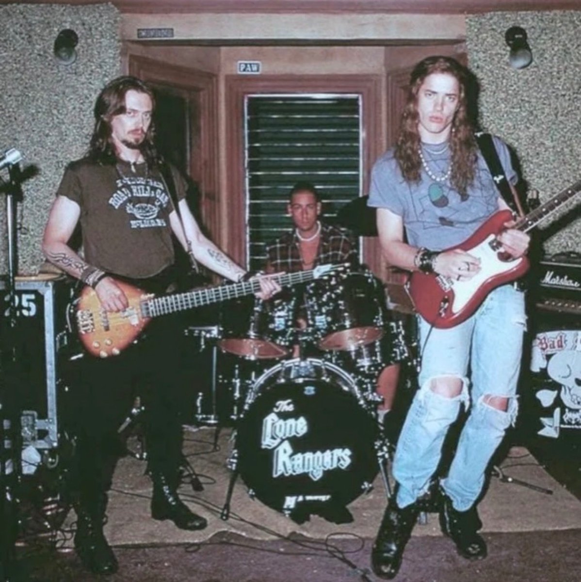 historyinmemes's tweet photo. Steve Buscemi, Adam Sandler, and Brendan Fraser share a moment on the set of Airheads during production in 1994.

Released in 1994, Airheads stars Brendan Fraser, Steve Buscemi, and Adam Sandler as the members of The Lone Rangers, an unsuccessful rock band that takes over a Los Angeles radio station in a desperate attempt to get its demo played on the air. The film blends rock music, absurd humor, and satire into a comedy that has since earned a devoted cult following.

Behind-the-scenes photos from the production capture the trio in their long hair, leather jackets, and heavy metal-inspired outfits, perfectly reflecting the style of the era. Supported by a cast that included Chris Farley, Michael McKean, Ernie Hudson, and Joe Mantegna, Airheads has remained a nostalgic favorite, remembered for its memorable characters, quotable dialogue, and unmistakable 1990s charm.