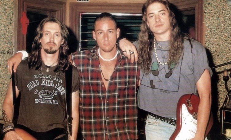 historyinmemes's tweet photo. Steve Buscemi, Adam Sandler, and Brendan Fraser share a moment on the set of Airheads during production in 1994.

Released in 1994, Airheads stars Brendan Fraser, Steve Buscemi, and Adam Sandler as the members of The Lone Rangers, an unsuccessful rock band that takes over a Los Angeles radio station in a desperate attempt to get its demo played on the air. The film blends rock music, absurd humor, and satire into a comedy that has since earned a devoted cult following.

Behind-the-scenes photos from the production capture the trio in their long hair, leather jackets, and heavy metal-inspired outfits, perfectly reflecting the style of the era. Supported by a cast that included Chris Farley, Michael McKean, Ernie Hudson, and Joe Mantegna, Airheads has remained a nostalgic favorite, remembered for its memorable characters, quotable dialogue, and unmistakable 1990s charm.