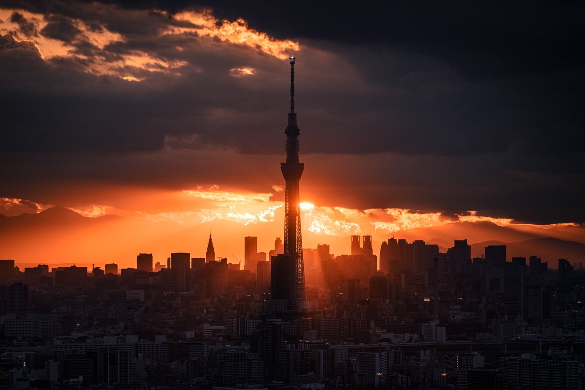 Nitto_Photo's tweet photo. 過去作発掘⑨
2023年10月撮影。

この日は千葉県市川の展望施設で1か月に2日だけある三脚使用のチャンスで、友人と昼過ぎに待ち合わせていた。

10月には、その施設からスカイツリーの向こうに沈む夕日が見られるため、東京の都市景観を美しく彩る夕景を狙っていたが、家を出た頃に空はどん曇りに。
これは無理か…？と諦めかけたが、到着した頃には雲にうまく隙間ができ、美しい天使の梯子が東京の街に架かっていた。

日が傾くにつれ空はよりダイナミックな姿を見せ、今までSNS上で延べ数百万回閲覧されたこれらの代表作が生まれたのである。

あれから早3年近く。
東京の空をずっと追いかけ続けているが、自分の目にも、ライブカメラなどの映像にも、これを超えるような光のショーはいまだ現れていない。