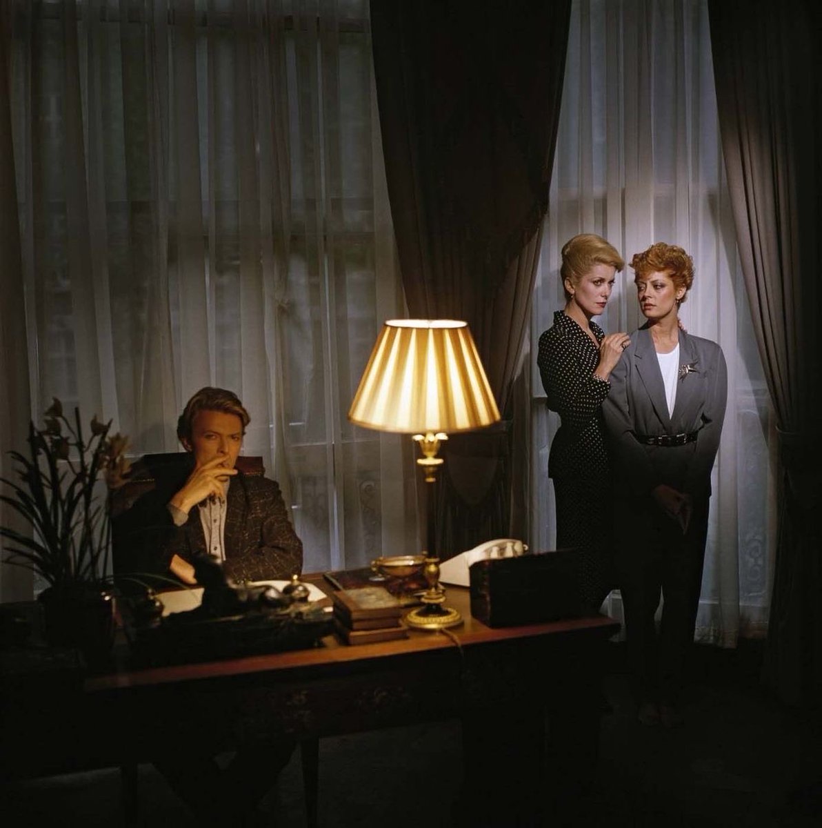 castcredits's tweet photo. David Bowie, Catherine Deneuve, and Susan Sarandon on the set of ‘The Hunger’ (1983) https://t.co/hJuAebGgTe