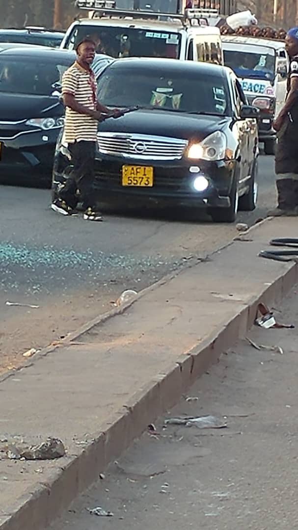 CrimeWatchZW's tweet photo. The driver of this black Nissan vehicle almost caused an accident due to his reckless driving. The driver of the kombi I was travelling in stopped to ask him why he was driving so recklessly.

The Nissan driver responded by getting out of his vehicle armed with a metal object and began assaulting the kombi driver and conductor. He then used the metal object to smash the kombi’s windows while passengers were still inside.

Passengers were forced to exit the kombi in a hurry for their safety. During the confusion, some passengers lost their belongings, including money.

What is most disturbing is that there were mothers travelling with their infants in the kombi, putting innocent lives at risk. We would greatly appreciate any assistance in identifying this individual and ensuring that the matter is reported to the police so that the law can take its course.

@PoliceZimbabwe, please take action!