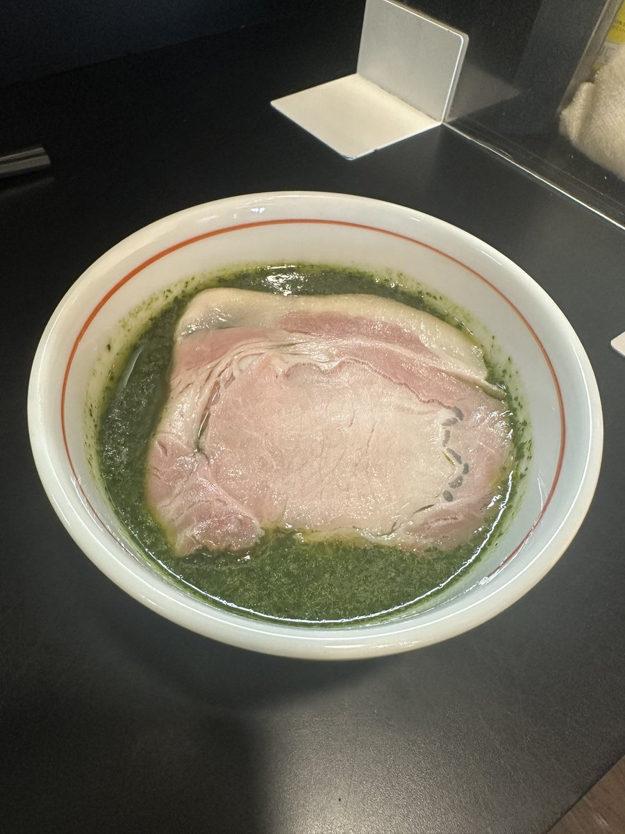 senjusan's tweet photo. らぁ麺飛鶏
地鶏・菰錦豚・貝・節・ハーブのつけそば大盛鶏増し豚増し
この日は京都の麺友斬人さんに誘われ鶏撃〜🐔🐔🐔💨
まあ誘われなくても行くんだけどね😏笑
待ち時間から今日は揃って白湯食べようか？なんて話してたが蓋を開けてみればふたりとも限定というお決まりのオチに🫣笑
名前からかなり期待できそうな匂いがプンプンしていましたが着丼すると圧巻のビジュアルに驚きを隠せない😳
白醤油ベースに動物の旨味が重なりきっとこれだけでもかなり美味しいだろうにと思うところにダメ押しの🌿がドーン🤗
バジルに紫蘇とイタパセを加えたという鮮やかな緑色のハーブは爽やかなスパイシーな香りと苦味や甘味も伴った清涼感を醸し出し食欲を増進させる🤤
麺側には複数の貝と節でとったお出汁がたっぷりと張られており麺のポテンシャルを引き立てる🤭
どういう構成か聞くの忘れたがこの出汁めちゃくちゃ美味くてこのまま冷かけで食べてしまいたかったのは内緒だが🤫笑
麺はいつも通り口あたり滑らかな喉越しともっちりとした食感の良さが秀逸😋
上質な鶏豚トッピングのクオリティは言わずもがなスープと麺そしてお出汁や具材までもが一体感ある見事な仕上がりで非の打ち所がないとはまさにこの事だな🤭
多種多様な素材の特徴を把握し完璧に調和させた長谷川さんらしい創造性に富んだ魅惑の逸杯はやっぱり今日も控えめに言って宇宙一でした😂