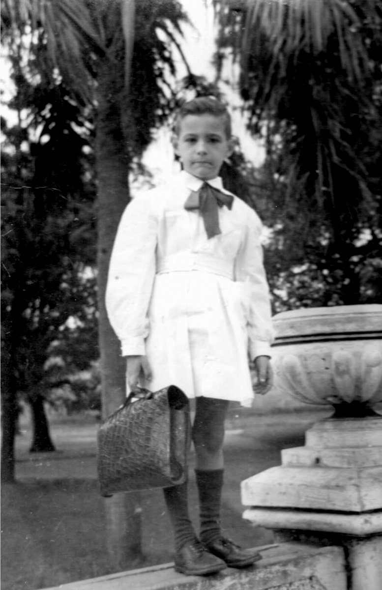 Rosariorecuerdo's tweet photo. Un pibe posa vestido con su delantal y su portafolios escolar en las 4 Plazas de barrio Belgrano, yendo o retornando de la escuela en 1956. https://t.co/Bn8EdDBcSO