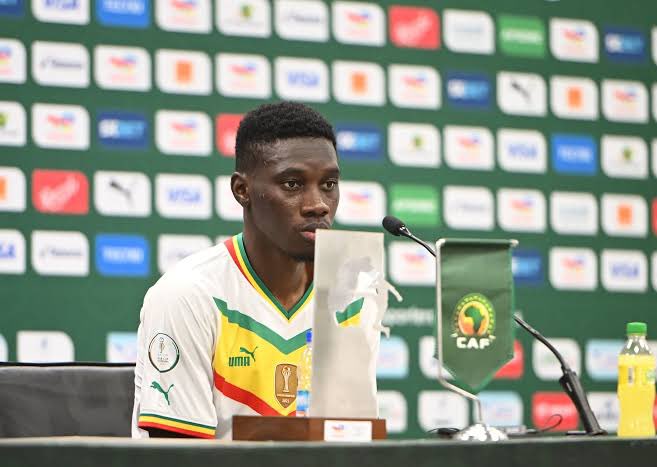 UTD_Seth001's tweet photo. 🚨 Ismaïla Sarr on the controversial penalty appeal for Youri Tielemans against Senegal:

🗣️ “This is football, not theatre. Tielemans gets to the ball first, Camara is doing exactly what every defender in the world is taught to do—protect his team and clear the danger. They arrive almost at the same time, there’s minimal contact after the challenge, and for me that is never enough to decide a World Cup match.

The Laws of the Game don’t punish every collision. A penalty should only be given when there is a clear foul—careless, reckless or excessive force. Simply touching an opponent after competing honestly for the ball is not a foul. Football has always been a contact sport.

VAR was introduced to correct clear and obvious mistakes, not to turn every tackle into a courtroom investigation. Every time football pauses for decisions like this, the game loses part of what makes it beautiful.

We fought for every metre, every duel and every second. Belgium were under pressure, and one whistle suddenly had the power to erase everything we had worked for. That’s difficult to accept.

If that’s a penalty today, then defenders should stop tackling altogether because any contact can suddenly become a spot kick. That cannot be what football is supposed to be.

Modern football is slowly becoming too soft. The players should decide these matches, not endless reviews and controversial decisions. We accept defeat when another team is better, but not when the game is taken away by moments like this.

No matter what happens, Senegal will continue fighting with pride because that’s who we are. But football has to protect fairness first, otherwise everyone loses.”