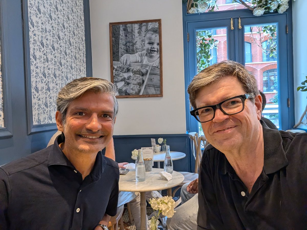 Arjunjain's tweet photo. Today. Maman, a small café near NYU, on the hottest day of the summer so far.

Across the table: Yann LeCun.

Thirteen years ago, I landed a postdoc at NYU - an office next to his, the year after AlexNet. I did not fully understand my luck.

He gave me half an hour, a few blocks from that office. We talked about world models - and I was a postdoc again, taking notes.

Here is the idea.

You are about to change lanes on a highway. Before you move, your head has already played it forward: the gap closes, the truck brakes, you make it - or you do not. You never touch the wheel until the future looks safe.

Notice what your brain just did. It took the world as it is, took an action you were considering, and predicted what happens next. Not once - for every option you had. Then it chose the one that ends well.

And notice what it did not do: play a movie. There is no 4K in your head. You tracked three things - gap, speed, truck - and threw the rest away.

𝗧𝗵𝗮𝘁 𝗶𝘀 𝗮 𝘄𝗼𝗿𝗹𝗱 𝗺𝗼𝗱𝗲𝗹. Yann's JEPA line of work makes it precise. First, the machine learns its own compressed representation of the world: an embedding that keeps what matters and drops the rest. Then the world model is a single function: current embedding, plus an action, predicts the next embedding. Chain it forward and the futures branch out; planning is picking the best path through them. No pixels anywhere in the loop. It is not a video generator.

Yann's one-line version: 𝘁𝗿𝗮𝗶𝗻𝗲𝗱 𝘄𝗼𝗿𝗹𝗱 𝗺𝗼𝗱𝗲𝗹 + 𝗼𝗽𝘁𝗶𝗺𝗮𝗹 𝗰𝗼𝗻𝘁𝗿𝗼𝗹 = 𝗶𝗻𝘁𝗲𝗹𝗹𝗶𝗴𝗲𝗻𝗰𝗲.

Most AI for the physical world still does not work this way. It maps what it sees straight to an action. 𝗔 𝗿𝗲𝗳𝗹𝗲𝘅, 𝗻𝗼𝘁 𝗮 𝗽𝗹𝗮𝗻.

That gap matters most in the places we build for - a plant, a grid, a pipeline. You do not get to discover consequences by trial there. Knowing what happens next is not a research question. It is the whole job.

And Yann is far from done. His new lab, AMI, raised a billion dollars to chase exactly this. The part I loved most: they plan to do it in the open - publishing the research, open sourcing a lot of the code. Frontiers move faster when they are shared.

Thirteen years ago I got lucky: the office next to his, at exactly the right moment.

Today, I got to say thank you.