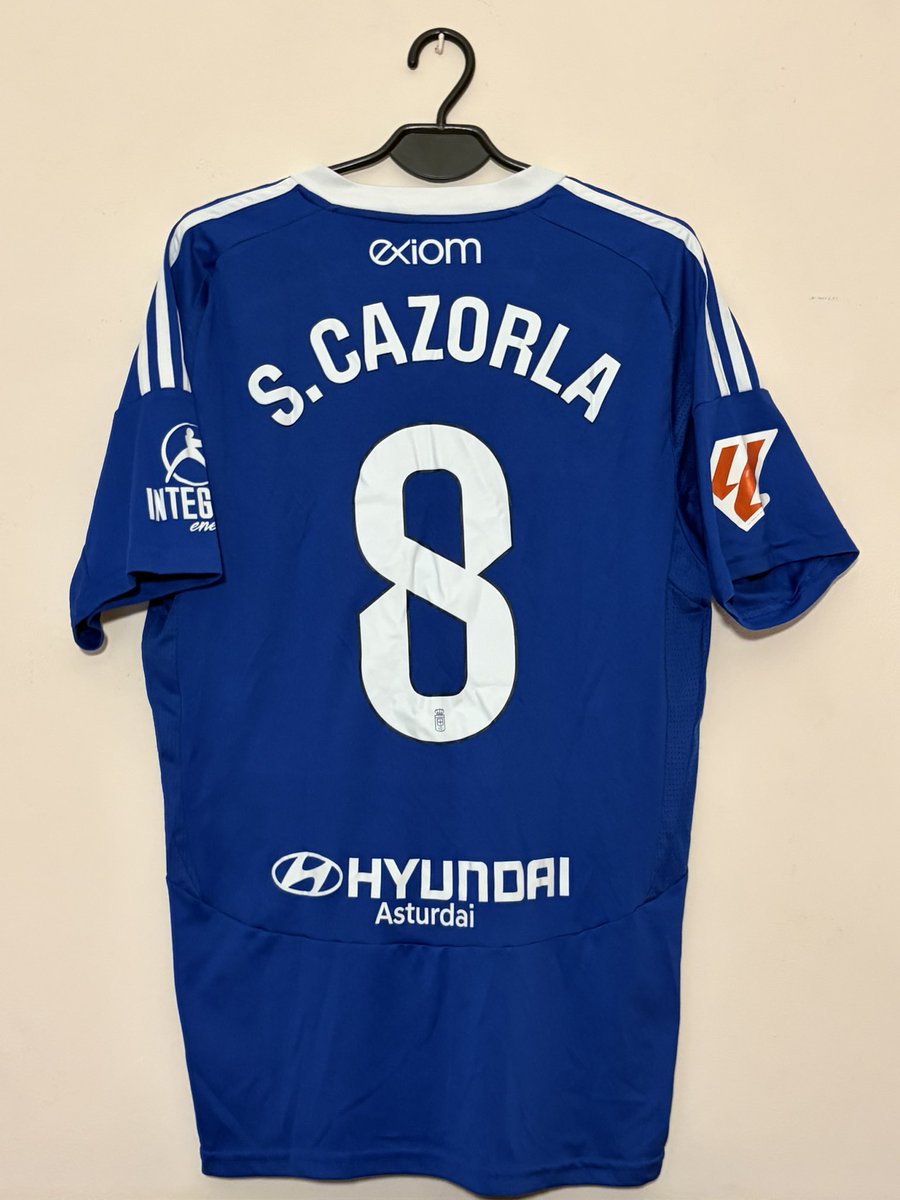 bulldozerOVD's tweet photo. La camiseta azul siempre iba con el 8 de @19SCazorla mientras estuviera aquí. Cada temporada el 8 a la espalda. El mejor futbolista que ha tenido el @RealOviedo. Y de casa. Más allá del fútbol, cada gesto con la gente, esa sonrisa siempre, y siendo más que un jugador. GRACIAS💙. https://t.co/5iD5OnOeUP