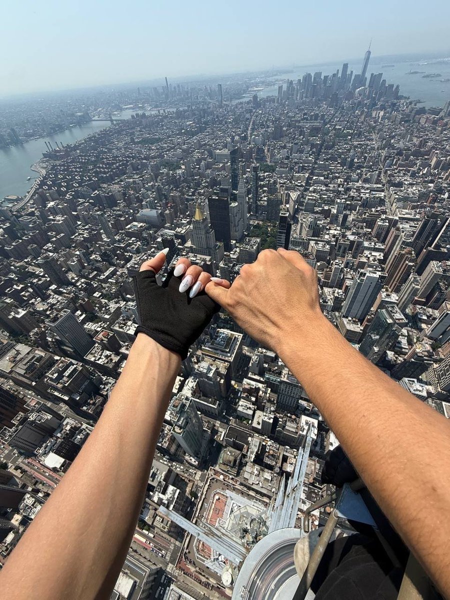 SarikaVats07's tweet photo. Russian rooftop climbers Angela Nikolau and Ivan Beerkus scaled the 1,454-foot spire of New York Citys Empire State Building on July 1, 2026, without safety gear.

At the top, they unfurled a peace banner reading:
"When the power of love beats the love of power."

The pair also appeared to get engaged before being taken into custody by the NYPD.