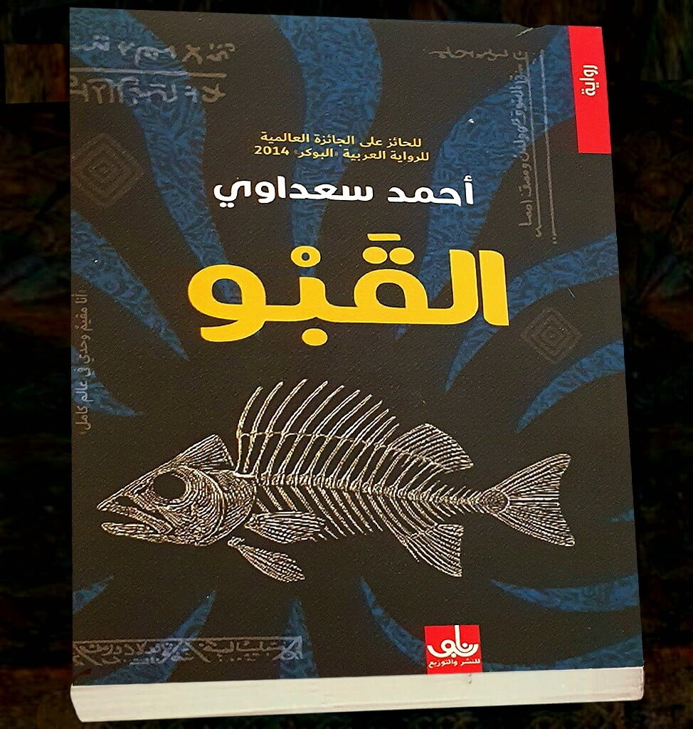 novels_books's tweet photo. من حكاية الطفل حديث الولادة الذي تخلّت عنه أمه كي لا يطمع به ملاك الموت، وتركته عند فضة العاقر في الهور. . . وسمّته «موشِلْنَه»، أي بمعنى: ليس لنا. "إنه طفل غريب لا ينتمي لنا يا ملاك الموت، يلله... اتركنا وارحل"... من هنا تبدأ الرواية ..

ومعها تبدأ السيرة الغريبة التي نُسجت حول سلالة موشِلْنَه، ذلك الجدّ الأسطوري، ابن الجنيّة التي خرجت من قلب هور "أم الزنابير" في محافظة ميسان جنوبي العراق ..

يكبر موشِلْنَه الذي لم يكن يوما من نصيب أمه شامة ولا فضة العاقر، بل بدا وكأنه صار تحت حيازة سكان «عالم البين» .. ثم يتزوج من هيلة، تلك الصبية التي أخبرته، منذ لقائهما الأول، أنها منذورة للطنطل إحفيّظ، وقيل إنها ابنة الجان حارس الماء ..

ومن هذه البذرة الحكائية، تنمو شجرة وارفة من الأساطير والموروثات الشعبية.. وتتضخم الحكاية مع الزمن حتى تغدو أسطورة تتناقلها الأجيال ..

فمن نسل موشِلْنَه وهيلة تخرج سلالة النساء اللاتي ورثن القدرة على مخاطبة سكان «عالم البين»... وصولا إلى حفيدات ذلك النسل العجيب. . بنات إفطيّم «گـاشيّة، وبريّة، سعديّة، بسْهِن، هَيهات» اللاتي يسميهن البعض «السحّارات». . . حيث الأوشام الغامضة التي تظهر على الأجساد، والزجاجات الصغيرة التي تحتفظ بأجزاء من الأرواح، والفوارغ القصبّية المغلقة بالعلك المر، والكائنات التي تتسلل عبر الشقوق الفاصلة بين المرئي والخفي ..

يعود إلى بغداد «وسام ابن سعديّة بنت إفطيّم»، الذي ما إن تشتاق إليه أمه حتى تشده إليها بحبل سرّي.. وبمكالمة واحدة تسحله من ألمانيا إلى بغداد، حيث هاجر بعد اختطافه وإطلاق سراحه أواخر عام 2006... فهو يؤمن، أو يكاد، بأن أمه تحتجز عشرين بالمئة من روحه داخل زجاجة صغيرة ..

وفي رحلة العودة ترافقه "أسيل"، صديقته الفرنسية ذات الأصول العراقية، الساعية إلى إجراء حوار مطول مع ابن خالته «رضا ابن وبريّة بنت إفطيّم»، ذلك الرجل الذي اختفى سنوات طويلة داخل قبو معتم، بعد تلك الحادثة التي جعلت رضا في بؤرة الخطر، فكان قرار الاختباء هربا من الملاحقات الأمنية .. 
بينما ظل أفراد العائلة يتجنبون الخوض في حكايته، كأنها خطيئة، أو سرّ لا يجوز الاقتراب منه ..

لكن وسام لم يكن يدرك أن القبو الذي ابتلع رضا يوما، وظن الجميع أن أمه أخفته بتعويذة لسبعة أعوام قبل أن يخرج في 2003، سيصبح هو ذات القبو الذي سيُحتجز فيه بعد أن يعود إلى بغداد ويلتقي الصديق رضا، الذي لم يستطيع أن يفطم نفسه عن هذه الحالة المرضية للقبو ..

«القبو» رواية ثرية بالميثولوجيا العراقية، تستحضر الأهوار والطنطل وحراس الماء، وحكايات الجدات التي تبدو للوهلة الأولى مجرد خرافات، لكنها تتحول تدريجيا إلى مفاتيح لفهم الشخصيات والواقع ..

وببراعة لافتة، يمزج ((أحمد سعداوي)) الواقعية بالفانتازيا والأسطورة، دون أن يختل توازن الحكاية أو تفقد بعدها الإنساني؛ فهو لا يستدعي الفولكلور بوصفه زينة سردية، بل يمنحه حياة جديدة، ويجعله مرآة تعكس المخاوف والذاكرة والندوب ..

ومن خلال هذا المزج، يتداخل عالم البشر مع ذلك الفضاء الغامض الذي يسميه أحفاد وشم السمكة «عالم البين»، حيث بنات إفطيّم بحيلهن وألاعيبهن. . . وحيث تتجاور الأساطير الجنوبية القديمة مع جراح العراق، فيغدو القبو الذي يحفره الكاتب تحت بيت عراقي، قبوا أعمق داخل الذاكرة الجمعية ..

فـ«القبو» ليست رواية عن ظلمة وباب مغلق، بل عن بشر عالقين بين الأمس واليوم، وبين الحياة والموت ..

إنها رواية عن شعب لم يخرج من القبو بعد، وما يزال عالقا في عتمته ..

لكن، وبرغم كل هذا التخبط والعتمة والأبواب الموصدة... ”دائماً هناك نور“.

من الرواية ...
– يروي وسام لأسيل خلاصة فكرة افطيّم عن عالم البين. فالله خلق الجن والإنس، وفصل بينهما بحاجز نسجته طبيعتهما المتباينة، وعلى الرغم من أنهما قد يشغلان أحياناً الحيّز نفسه في المكان، إلا أن الحساسية المفرطة للجنّ تدفعهم للابتعاد عن أماكن تواجد البشر، فالانسان أكثر كثافة من الجنّ، وقادر على إصدار أصوات مزعجة بحركاته وكلامه وأفعاله، تجعله سيّد المكان الذي يقيم فيه، وهناك سعة في الأرض تكفي لعدم مزاحمة البشر على أماكنهم.

يفكّر وسام: إن الحاجز بين العالمين وهمي وحقيقي في الآن نفسه، فهو يفصل بين العالمين فعلاً، غير أنه ليس خطاً، وإنما تجاور كتلتين. إن الحديث عن الحاجز يجعله حقيقياً داخل اللغة، على الرغم من عدم وجوده فعلاً.

يتساءل عن الوهمي والحقيقي أولئك الذين يملكون وقتاً لتأمل العلاقة ما ببن العالمين، وقد يكون المتسائل من عالم الجنّ أو الإنس، لا فرق، ومع كثرة الكلام تزايد الفضول، وصارت الرغبة باختراق الحاجز تتعاظم، فضولاً، وطلباً للتعرف، أو رغبة باستغلال قوى ما في العالم الآخر.

ليس هناك من يتذكّر تلك الفترة التي كان فيها الإنس والجن يتحدثون عن الحاجز الطبيعي وكأنه بديهة ومسلّمة من المسلّمات، لأن الجميع يعرف بأنها لم تعد كذلك، فقد نجح بعضٌ من الجن بالعبور إلى عالم البشر، والقيام بجولات فضولية، أو الاقدام على مشاكسات قد تسبب مضارّ كبيرة للبشر تودي بحياة بعضهم.

تزايد الحرس على تلك الثغرات التي أحدثها الجنّ المشاكس، ولكن سدها يجب أن يجري من الجهة الثانية أيضاً، فتدخل هنا جنّ طيب لاستجلاب المساعدة من البشر.

هكذا، بعد حين من الزمن يصعب تحديد أمده تكونت علاقة ما بين الطرفين، بين الأشرار من الجهتين والأخيار، وصار هناك مقيمون دائمون عند الحدود، حتى أن طبيعتهم تغيّرت مع مرور الزمن، وصار الحاجز الوهمي السابق عالماً ثالثاً، صارت إفطيّم تسمّيه "عالم البين" جرياً على المرويات الشفاهية لسلالة جدّاتها.

تعرف إفطيّم ما يراه البشر في عالم البين، غير أنها تجهل ما يراه الجنّ، لأنها تحتاج أن تكون من طبيعة الجان الخفيفة نفسها حتى تعرف ما يرونه، كما هو الحال بكثافة وثقل عالم البشر التي تجعل الجن غير مرئيين فيه، ولا يستطيعون أن يسيروا في الأسواق ويأكلوا مع الناس.. إنهم يتلبّسون أحداً ما ويتصرفون من خلاله، ولا يستطيع أحدٌ رؤيتهم على الحقيقة.

في عالم البين، كما هي مسافة التداخل ما بين عالمي اللاهوت والناسوت، يأخذ الجان هيئة بشرية، لأنها هيئة من ممكنات خيال البشر. ولكن كيف هي هيئة البشر في أعين الجان في هذا العالم؟

كانت إفطيّم ترى جدتها الكبرى هيلة إمرأة بيضاء البشرة عظيمة الجثّة بشعر أحمر مرسل وأوشام خضراء داكنة تغطّي كامل جسدها مثل شبكة إفعوانية، تتمشّى مثل مسيح على ماء الهور. وتعرف أن ما تراه ليس هيلة، وإنما أحد السكان الأخيار لعالم البين.

إفطيّم نفسها وأسلافها من الجدات اللائي لا تعرف عددهن، هن من سكّان عالم البين، ولا أحدٌ آخر من البشر مؤهل لدخول هذا العالم غيرهن.

يقول ساكن عالم البين المتلبّس بهيئة الجدة الكبرى هيلة:
ـ لم يكن من اختيارنا أننا وُجدنا في هذا العالم، بل من اختيار أسلافنا، ولا نملك القدرة للعودة إلى عالم الجان، فقد تغيرت طبيعتنا، ولم نعد منهم، ونحن محكومون ها هنا بمهمة عالية: أن نحرس البوّابات التي تنفتح ما بين العالمين، ريثما ننجح في إغلاقها معاً، نحن وأنتم، ذات يوم.

ـ ولكن لماذا هو قدرنا أيضاً؟
تساءلت إفطيّم، حين كانت صبية، في زيارتها الأولى لعالم البين، ولأن السؤال معتاد ومتوقع، فلم يرتجف شيء في هيلة [أو قناع هيلة على وجه شخص من عالم البين] حين ردّت:
ـ لأنك وشبيهاتك من هذا العالم، ولستنّ من عالم البشر تماماً. إنه قدركنّ وعليكن تقبله.
ـ وماذا لو تمردتُ، وامتنعت عما يُطلب منّي؟
ـ إنها مهمة عالية، لأننا نتقبّلها. من يرفضها.. تتركه.