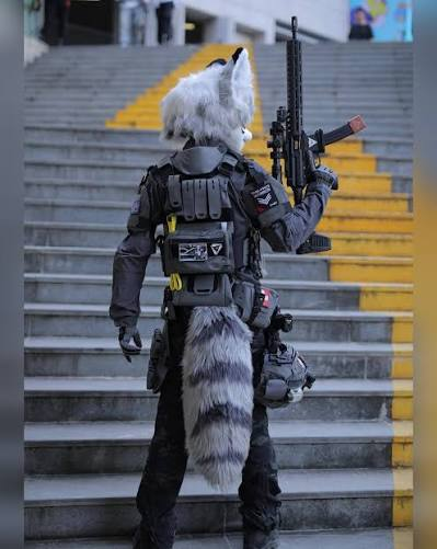 Tyras_Mikhail's tweet photo. It's absolutely hilarious to me that anti-milfurs say "Lol, I'm glad AC banned tactical gear, wear something creative instead of LARPing as a jackboot!" when Asian fursuiters wearing tactical gear absolutely mog 99% of uwu sparkledog suits you see in American furcons. https://t.co/AgfG76Pckq