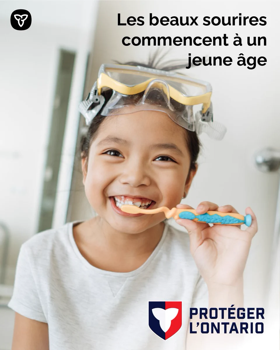 Une fillette qui se brosse les dents avec des lunettes de natation sur la tête