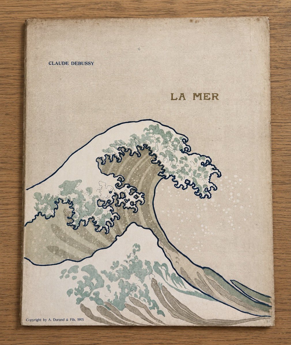 AmisRavelJapon's tweet photo. きょうは波の日（7/3）だそうです。
当会アーカイブのドビュッシー《海》の初版譜（1905年デュラン社、ピアノ連弾版）。葛飾北斎の「神奈川沖浪裏」のデザインがあしらわれています。 https://t.co/VKwatQ4CbL