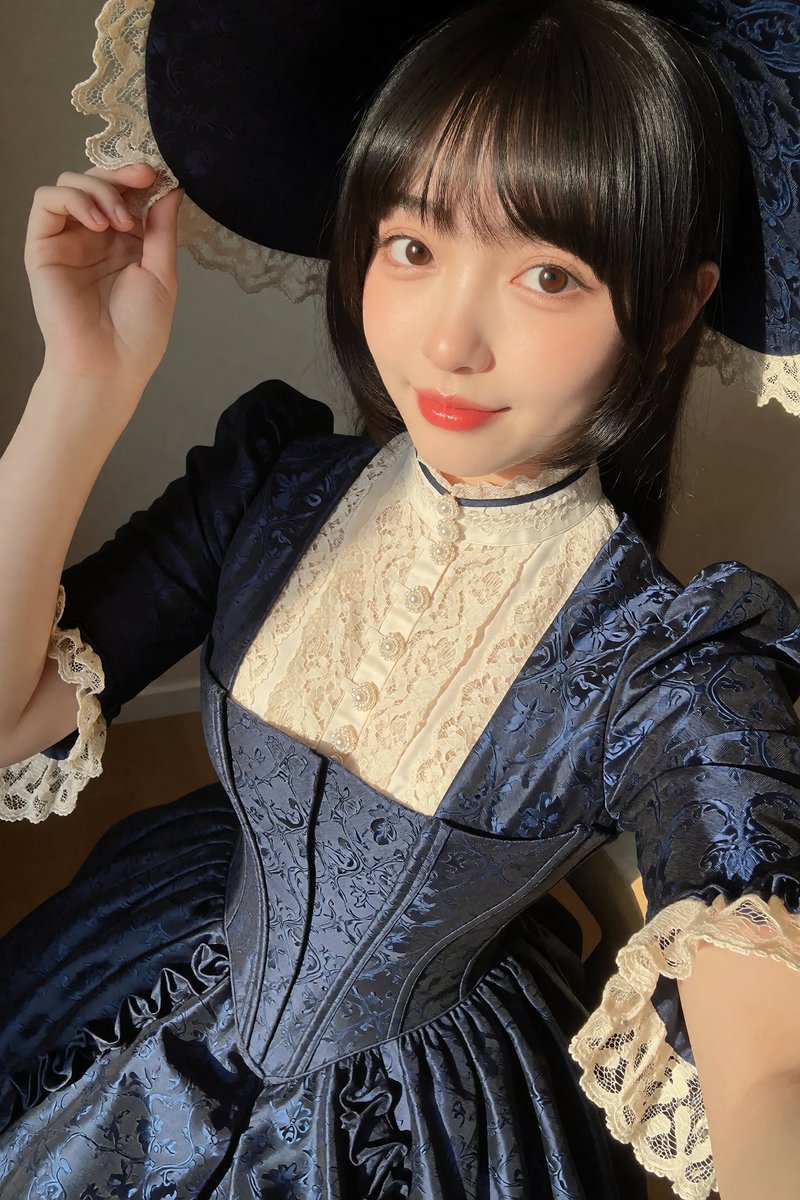 JTFAI_1917's tweet photo. 今回デザインした衣装は
「ヴィクトリアンスタイルのコルセットドレス」です✨ 

プロンプトは下部に記載しています。  

プロンプトは自由に改変・調整していただいて大丈夫です！  

使用条件は特にありませんが、 #衣装試着lv0 を付けて【リポスト→引用】でご使用いただければ、他のキャラクターがこの衣装を着ている姿を私も見られてとても嬉しいです。  

実在人物以外ならどんなキャラクターでもOKです。
版権キャラクターの場合は、キャラ名と出典を明記していただけると助かります！  

プロンプト： (SD用プロンプトはリプ欄)
A full-length Victorian-era gown with a dramatic hourglass silhouette. 
The dress features a highly detailed, tightly laced corset emphasizing a narrow waist. 
The main fabric of the dress is a luxurious deep midnight blue silk with intricate, subtle damask dark patterns woven into the fabric that catch the light. 
The high collar and yoke are made of a contrasting cream-white lace, adorned with a delicate row of tiny pearl buttons down the front. 
The long sleeves are puffed at the shoulders (leg-o-mutton style) and taper to tight cuffs with cream lace trim. 
The voluminous A-line skirt features elegant pleats and a subtle ruffle hem, showcasing the exquisite tone-on-tone floral jacquard texture throughout the gown. 
Hyper-detailed fabric texture.