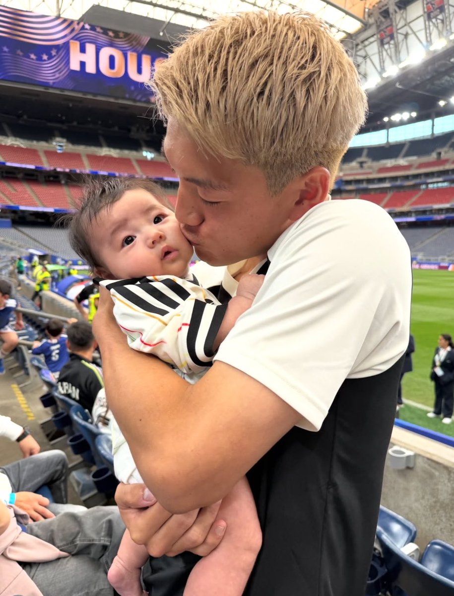 Iron_fist_sanc's tweet photo. 【感動実話】
日本のエース、堂安律選手がパパになりました。
２０２６年Ｗ杯の激闘の裏で、愛娘に見せた素顔が話題です。

■ ピッチ上の闘犬が見せた慈愛の表情
ブラジルとの死闘を終えたスタジアムでの一コマです。
エースとして戦い抜いた彼を待っていたのは、小さな愛娘でした。
普段の激しいプレースタイルからは想像できない穏やかな顔。愛おしそうに頬にキスをする姿に、世界中が心を奪われました。

■ １０番を背負うパパとしての覚悟
４年前の大会では若き期待の星として暴れ回っていた彼。
今大会はの美玖さんと愛娘という、最強の家族が支えです。
守るべき存在ができたことで、そのプレーには凄みが増しました。
パパになった堂安選手の進化は、もはや誰にも止められません。

■ 世界が絶賛した史上最高のオフショット
小さな「ＲＩＴＳＵ」のユニフォームを着た愛娘との絆。
この写真は海外メディアでも大会の美しい瞬間として紹介。
過酷な勝負の世界に咲いた、一輪の花のような家族愛です。最強のパパとして、彼は次なる高みへと力強く視線を向けました。

■ 最後に
大黒柱として、そして日本代表の柱として彼は歩みます。家族の愛を力に変えて、これからも走り続けることでしょう。

パパになった日本の１０番の物語は、まだ始まったばかりです。
大切な人の存在こそが、限界を超える一番のスパイスになる。

パパの顔になった堂安選手を、全力で応援したい人は保存。