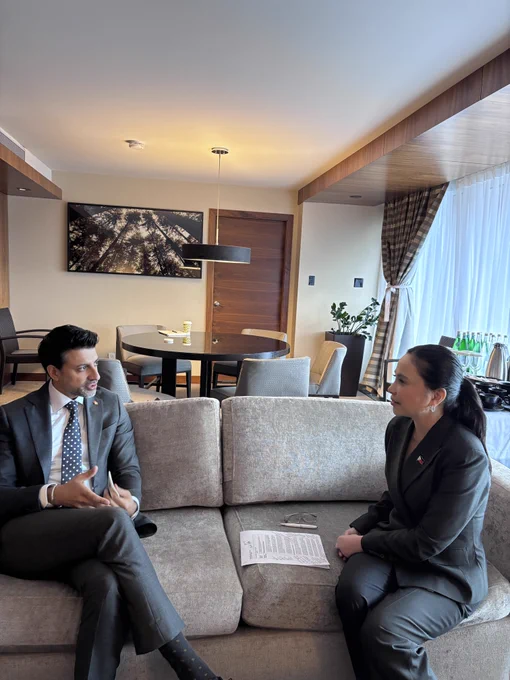 Minister Sidhu and the Philippines’ Secretary Aldeguer-Roque sitting down and speaking. A document rests on the sofa between them, with a dining area visible in the background. 