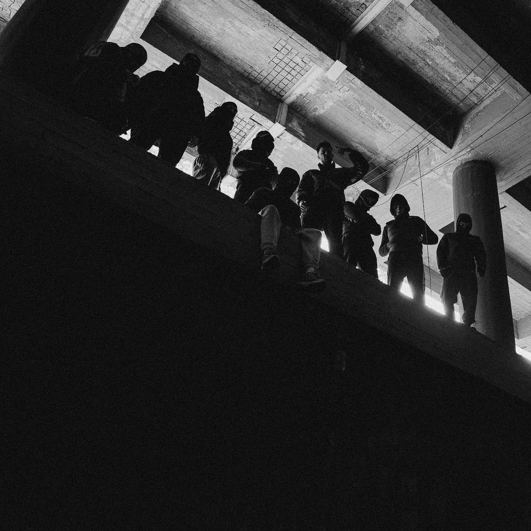 teeheehyung's tweet photo. Is BTS redefining the word “Hooligan?”

a central theme is the linguistic subversion of the word ‘hooligan.’ traditionally, a hooligan is a violent, disruptive troublemaker.  with the viral smash hit, bts strips the word of its negative connotations and transforms it into a badge of honor for creative liberation and non-conformity

notice that the adjective hooligan does not modify a person or an act of physical violence; it modifies the ‘beat.’ by shifting the site of delinquency from a street corner to the musical production itself, the song argues that their destruction is strictly sonic. they are intentionally “acting a fool.” in the context of a highly corporatized and tightly disciplined music industry, choosing to be unpolished is a radical, deliberate act of autonomy. 

traditional hooliganism relies heavily on a mindless, destructive mob mentality. bts uses first-person plural pronouns to completely flip this dynamic, turning a chaotic crowd into an organized, globally conscious collective (everyone laughing with bts in the tour stops are extremely conscious of this). 

section 1: instead of rallying a crowd to tear down physical spaces, the lyrics invite the collective 우린, ‘We’ to treat the world as a blank canvas : ‘Every one o' you a muse’

section 2: instead of comparing the crowd to a chaotic stadium or a street riot (the traditional spaces for hooligans), hobi compares the mass of people to a ‘campus.’ a campus is a localized hub for intellectual growth, youthful energy, and shared discovery. 

section 3: traditional hooligan gangs are highly exclusive, territory-based, and identity-restrictive. hobi flips this rule by shouting “Gather up everybody, one two” followed by “I can never ever choose.” by refusing to choose or exclude anyone, the track redefines the group from a localized turf-gang into an open-door global collective where anyone who values raw self-expression can belong!! 

there has been 3 redefining of the negative here: violence to sonic disruption (the knives clattering, laughing), mindless mob to an intellectual collective & societal delinquency to radical autonomy). 

for bts, having a track like hooligan is not an act of immaturity but a sophisticated, highly calculated reclamation of freedom.

#hooligan #bts