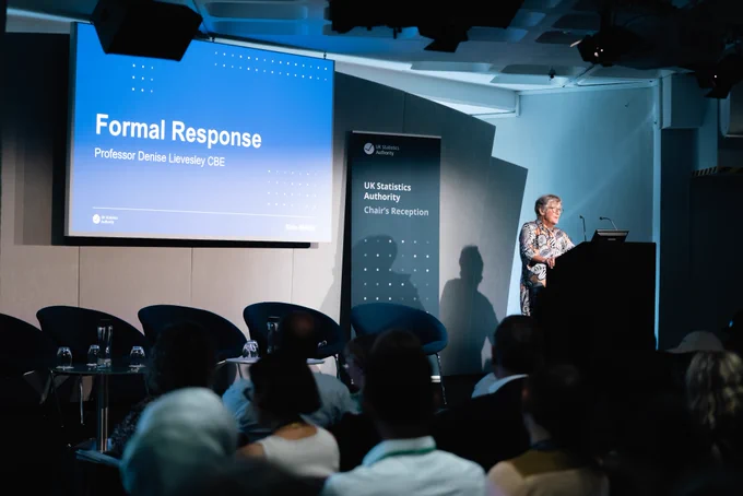 Professor Denise Lievesley CBE stood at lectern in front of presentation slide that reads formal response.