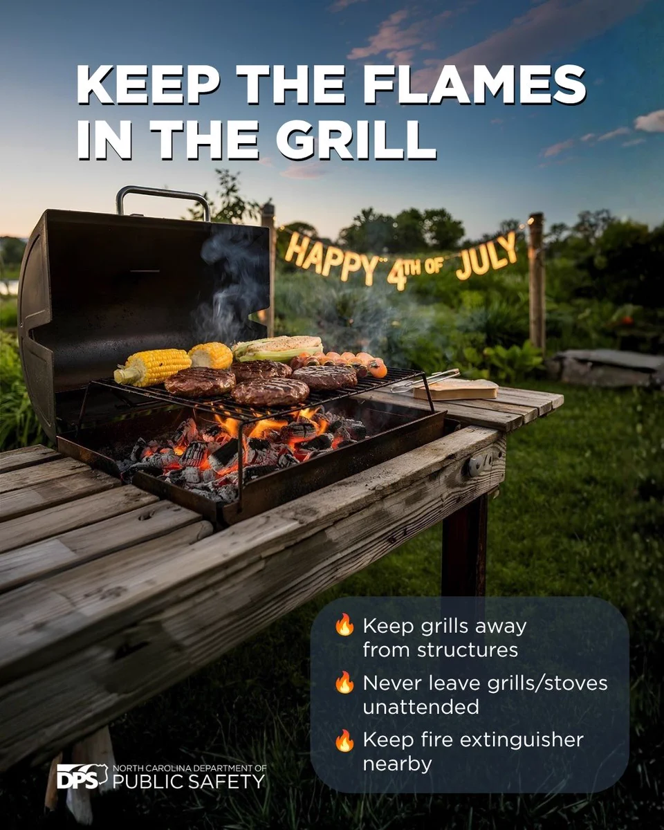 Outdoor barbecue with food grilling over open flames. A banner in the background reads, "Happy 4th of July." Text advises to keep grills away from structures, never leave grills/stoves unattended, and keep a fire extinguisher nearby. North Carolina Department of Public Safety logo is visible.