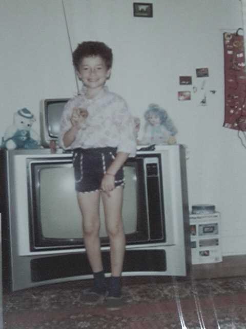 alexolegimas's tweet photo. Happy 4th of July everyone. 

I came here as a kid at 9 years old, not knowing a single word of english, lived on food stamps in section 8 housing. My parents cleaned houses while my sister and I collected cans for recycling. Our clothing was all donated and our furniture was things we found on the curb (here I am in front of our "tv set", the broken one being used as a stand for the little working b/w one).

But this country gave us an opportunity--to learn, to work hard and earn something for it. "Grateful" does not begin to cover it. I owe this country and its people everything I have. 

Thank you America, happy 250 to the idea.