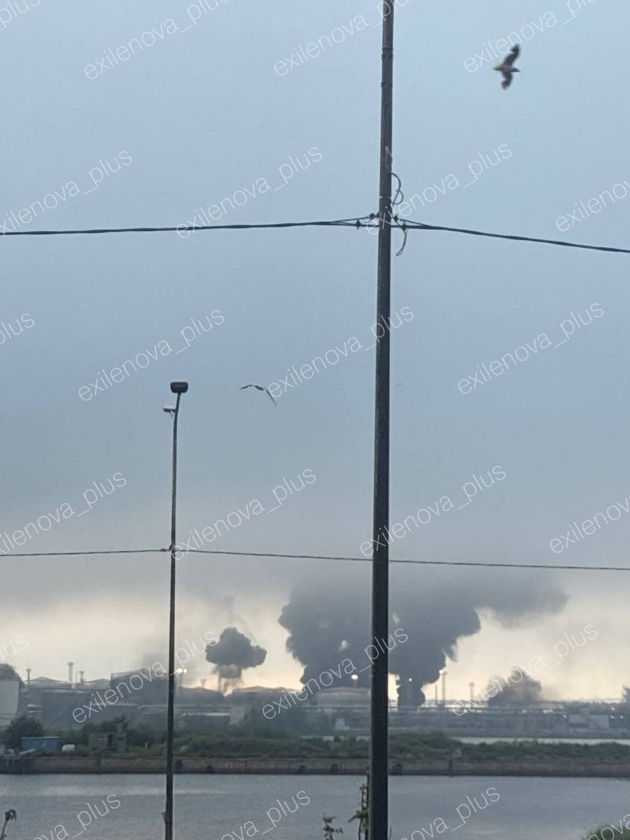 Osinttechnical's tweet photo. Multiple Ukrainian attack drones just hit Russia's St. Petersburg oil terminal, setting the facility ablaze. 

Explosions continue as multiple columns of smoke are rising from the port area. https://t.co/ZIJtr3AAgh