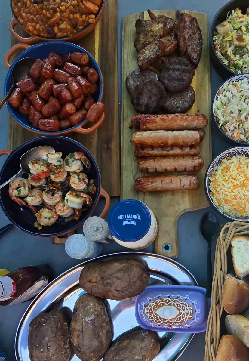 DeanoBacherro's tweet photo. Family BBQ time. Baked spuds, Garlic butter prawns, Hot dog burnt ends, Cowboy beans, various meats, homemade Caesars, and slaw. For dessert, a bowl of cocktail flavoured macarons 😎 #bbq #summertime #familytime #tasty #foodpics https://t.co/MIU0cWvwBJ