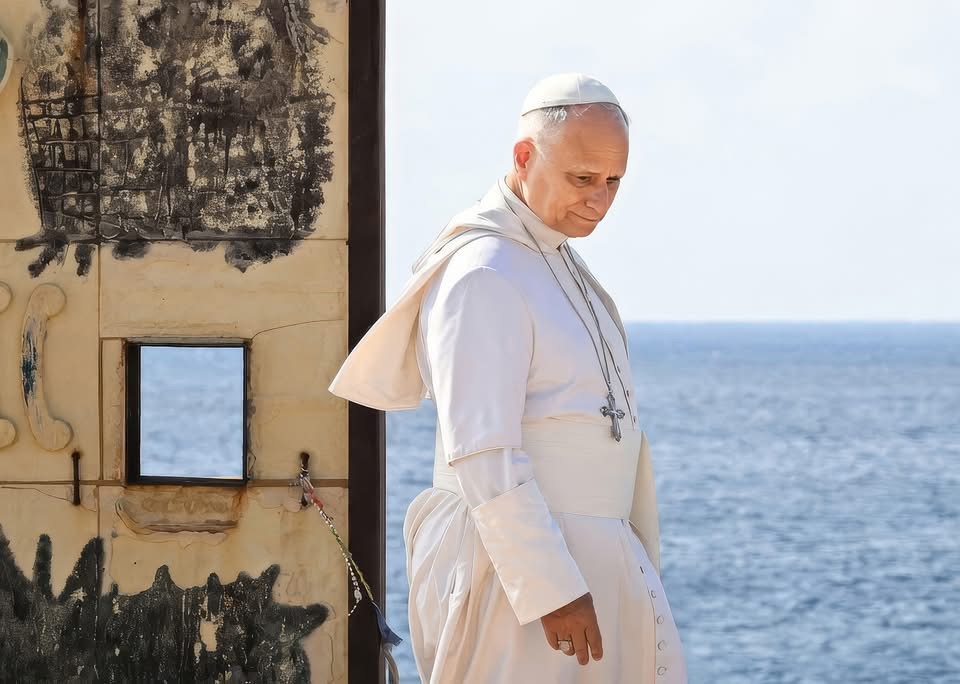 BMitraglia's tweet photo. ✍🏻 Roberto Riccardi

“Non venite”. Questo avrebbe potuto dire il Papa a Lampedusa, se avesse veramente voluto salvare vite e combattere il traffico di esseri umani.

Non per cinismo, ma per quella verità elementare che ogni operatore di frontiera conosce e nessun pulpito pronuncia.

Ogni messaggio di accoglienza senza deterrenza, senza rimpatri e senza un confine credibile diventa un volantino pubblicitario nelle mani dei trafficanti libici.

Invece Leone XIV ha scelto il copione opposto. Lo stesso copione di tredici anni fa. Stessa isola, stesse tombe, stesse lacrime, stesse parole. E lo stesso risultato: nessuno.

Oggi l’aereo papale è atterrato alle 8.54 su un’isola che conosce il copione a memoria.

Inginocchiamento al cimitero dei senza nome. Sosta alla Porta d’Europa. Stretta di mano ai migranti dell’hotspot. Giro in papamobile. Messa con quattromila fedeli. Omelia. Decollo alle 12.54. Quattro ore esatte. Il tempo di una compassione cronometrata.

La data non è casuale. Prevost, nato a Chicago, sceglie il duecentocinquantesimo anniversario dell’indipendenza americana per atterrare sull’isola-simbolo del Mediterraneo.

E da lì lancia il suo messaggio a Washington: “Accogliere gli stranieri con compassione e generosità”. Un Papa statunitense che usa Lampedusa come pulpito contro le politiche migratorie di Trump.

La pastorale si fa geopolitica, il pellegrinaggio diventa posizionamento. E nessuno, nel coro mediatico, lo rileva.

L’omelia al campo sportivo Arena è un condensato di retorica consolidata. I migranti sono “vittime di decisioni prese e decisioni mancate”. Ma quali decisioni, esattamente?

Il Papa evoca “il disinteresse per il bene comune e la corruzione nei luoghi di provenienza”. Otto parole. Otto, per liquidare Stati falliti, guerre tribali, regimi cleptocratici, fondamentalismo islamico.

Otto parole contro le migliaia spese per colpevolizzare l’Europa. Il bilancio delle responsabilità, nel magistero migratorio vaticano, resta quello di sempre: asimmetrico fino alla caricatura.

Poi il capolavoro retorico: “Il muro invisibile fra il mare dei naufraghi e quello dei vacanzieri”.

Una frase che suona bene dal pulpito. Ma chi conosce Lampedusa sa che i lampedusani portano questo fardello da vent’anni senza che nessun governo – e nessun pontificato – abbia mai dato loro risposte strutturali.

Trasformare i turisti in colpevoli per il solo fatto di essere in vacanza è moralismo a buon mercato. Quei turisti sono l’unica economia che tiene in vita l’isola. Ma al campo sportivo Arena si applaude, e tanto basta.

Nell’hotspot di contrada Imbriacola ci sono 136 persone. Tra loro, cinquantuno minori non accompagnati. Cinquantuno. Il Papa non visita l’hotspot, come non lo visitò Francesco.

Quei cinquantuno ragazzi, spediti in mare da soli attraverso la Libia, raccontano però una storia che nessuna omelia osa affrontare: chi li ha mandati? Chi ha pagato i trafficanti? Dove sono le famiglie?

La narrazione dell’infanzia innocente naufragata nel Mediterraneo si scontra con un’industria criminale che usa i minori come passaporto d’ingresso, sapendo che un minore non accompagnato non può essere espulso.

Non è cinismo: sono i dati di chi lavora sul campo. Ma dal pulpito di Lampedusa, il meccanismo non viene mai nominato.

Un bambino di nome Leo consegna al Papa una letterina: “Sono sbarcato qui da solo dieci anni fa”.

La scena è commovente. Ma la domanda che nessuno pone è brutale: chi ha messo un bambino da solo su un barcone diretto in mare aperto?

Quel gesto, nel racconto mediatico, diventa simbolo di speranza. Nella realtà, è la prova di un crimine. Due letture della stessa immagine. Una fa audience, l’altra fa politica. Indovinate quale prevale.

Gli attivisti presenti completano il quadro con la grammatica di sempre: l’hotspot è “un luogo di detenzione”, Frontex sottopone i migranti a “interrogatori” lesivi della dignità, le procedure di screening sono disumane.

Denunciano cioè l’unica cosa che funziona: l’identificazione.

Quell’identificazione senza la quale non esiste politica migratoria, non esiste distinzione tra chi ha diritto all’asilo e chi no, non esiste contrasto al traffico di esseri umani. Ma nella narrazione dominante, identificare è già discriminare. Controllare è già opprimere.

“Un piano strategico di lungo periodo”, invoca Leone XIV. Magnifico. Dopo tredici anni, due pontificati, migliaia di morti e miliardi spesi, siamo ancora alla fase della raccomandazione generica.

Nel frattempo, il modello Albania – l’unico tentativo europeo di spezzare il legame tra partenza e permanenza – viene implicitamente condannato come contrario alla “dignità della persona”.

Eppure è quel modello, pur stretto fra vincoli e garanzie imposti dai giudici europei, che per la prima volta ha introdotto un principio elementare: chi non ha diritto alla protezione internazionale non deve trasformare automaticamente lo sbarco in permanenza europea.

Un principio che il magistero vaticano non riesce nemmeno a pronunciare.

La parabola del buon samaritano, evocata per l’ennesima volta, ha un dettaglio che il magistero migratorio dimentica sistematicamente: il samaritano aiuta un uomo. Non apre un corridoio permanente tra Gerusalemme e Gerico.

Non finanzia una flotta di taxi del mare. Non denuncia chi costruisce locande sicure lungo la strada. Soccorre, e poi affida a una struttura. Il gesto è individuale, concreto, delimitato.

Trasformarlo nel fondamento teologico di una politica migratoria continentale è un’operazione che il Vangelo non sostiene e la realtà smentisce.

“È tempo di riconoscere che l’appartenenza religiosa non deve mai diventare motivo di discriminazione”, aggiunge il Papa. Una frase che, nel contesto di Lampedusa, vuol dire una cosa sola: non discriminate i migranti musulmani.

Giusto. Ma allora si abbia il coraggio di completare il discorso: si parli anche della discriminazione che i cristiani subiscono nei Paesi da cui quei migranti fuggono.

Si parli delle chiese bruciate in Nigeria, dei copti massacrati in Egitto, dei cristiani perseguitati in Pakistan. Il magistero dell’accoglienza senza distinzioni funziona in una sola direzione.

E quella direzione è sempre la stessa: verso l’autocritica dell’Occidente.

Alle 12: 54 l’aereo decolla. Le telecamere si spengono. Lampedusa torna a essere quello che è sempre stata: un avamposto dimenticato che si ricorda di esistere quando serve uno sfondo fotogenico per la coscienza europea. I lampedusani restano con i loro problemi.

I cinquantuno minori non accompagnati restano nell’hotspot. I trafficanti libici restano in affari.

E tra qualche anno, un altro Papa verrà a inginocchiarsi sulle stesse tombe, a pronunciare le stesse parole, a versare le stesse lacrime.

Tredici anni di pellegrinaggi, omelie e zucchetti portati via dal vento. Il Mediterraneo, intanto, continua a inghiottire. Non ha mai smesso.