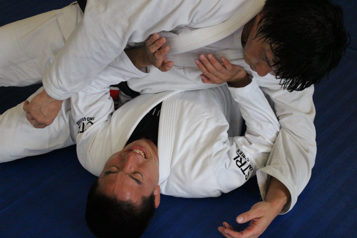 BJJCHANNEL's tweet photo. 一応、私は柔道整復師という国家資格を持っています。
ペーパー試験は試験前の最大瞬間風速が一番知識がある時で今ではかなり忘れてますし、そもそも自分には向いていないというのが大きく、現在は免許を使っていません。

その、少しだけ勉強した解剖学的な知識と、ヘンリー先生とのスパー経験を踏まえて感じたことを書きます。

ヒクソン先生やヘンリー先生の技法は、スピリチュアルや都市伝説的なものではほぼありません。

最近のニーオンベリーは、骨盤や下腹部あたりに乗せて、ポジショニングを重視するやり方が多いかと思います。

現在はフィットネスとして柔術を楽しむ方も多いですし、道場経営を考えても、安全性を重視するのは当然だと思います。

ただ、30年ほど前、グレイシージャパンがあった時代から柔術をやっている方の中には、ニーオンフェイスや、かなり痛いニーオン胸骨をする方もおられました😂

中には、袖や襟を引き上げながらニーオン胸骨をする方もおられます😂

ニーオン胸骨に関しては、ヒーロン・グレイシー先生もセミナーで、
「仲間にはやっちゃダメ」
と言われていました。

ヘンリー先生のプレッシャーの考察で、胸骨の上にある膻中（だんちゅう／左右の乳頭を結んだ線のちょうど真ん中あたり）に乗っている、という説明をされる方もおられます。

ただ、グレイシージャパン時代から柔術をされている方に、実際にニーオン胸骨を喰らった経験から言うと、ヘンリー先生のプレッシャーはそれとは違うものだと感じました。

グレイシー系では「胸と胸を合わせる」とよく言われます。

ただ、単に胸と胸を合わせるだけで呼吸困難になるわけではないと思います。

私がヘンリー先生とスパーして感じたプレッシャーは、常にニーオンストマックをされているような感覚でした。

胸と胸がくっついた状態、つまり膻中と膻中が合っているような状態から、さらに身体をわずかに捻ることで、脇腹あたりを使って相手の胃や鳩尾に圧をかける。

その結果、呼吸を遮断していく技法に近いのではないかと思います。

体重の方向が鳩尾・胃・横隔膜あたりに落ちている。

肋骨や呼吸筋の動きを潰されている。

この辺りがポイントかなと思います。

身体を捻られて、さらに圧が掛かり、逃げる方向も塞がれている。最強のプレッシャーを与えるのはスカーフホールドとヘンリー先生は言われますが、その形がそれに近いのかなと思っています。

力で押すのではなく、重さが抜けずに乗り続けている。

このあたりが重なった時に、あの独特の息苦しさが生まれるのではないかと考えます。

※間違っていたらすみません。

セミナー中、柔術インストラクターの江嶋先生が、ヘンリー先生のプレッシャーを受けた際に、

「タップができない！」

と驚いて叫ばれていました。

その気持ちはすごく分かります。

まさに、経験した人にしか分からない、思わず声が出てしまうような感覚です。

しかし、サイドポジションで上に乗っているヘンリー先生には、力みがまったくありません。

感覚としては、上に鯨が乗っているような感じです。

しかも、常時ニーオンストマックを身体でされているようなプレッシャーが続きます。

人によっては、武術系YouTubeや都市伝説系の話のように感じられるかもしれません。

トップからはウエイトディストリビューションとリラックスしたコネクションによって、スパーリングのある寝技の攻防の中で相手の呼吸を奪い、どんどんスタミナを削っていく…

そのためには、1分から2分ほど、相手の呼吸筋の上に乗り続けることが必要になります。

下の人は1分逃げられなかったらかなりヤバい状況になります。

息が吸いづらい
↓
呼吸が浅くなる
↓
パニックに近い感覚になる
↓
スタミナが急激に削られる

私はこの過程を何回か経験しました😂

下がブリッジをする時に上は腰を捻り圧を掛けるのでカウンターみたいな状態になって更に苦しさが倍増する為、諦めて逆に逃げようとせずに何もしない方がいいかもしれないです😂

リラックスを強調されますが、上の人は力んでいると身体が固まり、相手に返されやすくなります。

だからこそ、力で押さえつけるのではなく、呼吸筋の上にバランスボールのように乗り続ける感覚が必要になります。

これが、ヒクソン先生、ヘンリー先生のプレッシャーの一番恐ろしいところだと思います。

ただ重いわけではなく、ただ痛いわけでもない。
力みがないのに逃げられず、呼吸だけが奪われていく。
そういう、経験しないと伝わりにくい技法なのだと思います。

最初は難しいですが、何度もトライ＆エラーしていくと身につくと思います。