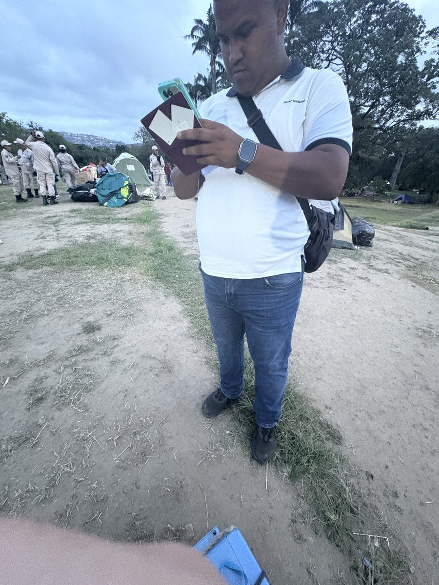 YOYOPRESS's tweet photo. 🚨 ESTE AGENTE DEL SEBIN INTERROGA Y FOTOGRAFÍA EL PASAPORTE DE PERIODISTA BRITÁNICA EN EL PARQUE DEL ESTE

Catherine Ellis, periodista británica, denunció que agentes de inteligencia la abordaron mientras ayudaba a una familia damnificada a mudarse dentro del parque.

La PRIMERA pregunta no fue sobre seguridad. Fue: ”¿eres periodista?”

Le tomaron fotos al pasaporte. Le preguntaron dónde vivía.

Cuando ella preguntó por qué, la respuesta fue: “porque no existe una prensa realmente libre.”

Ellis ya portaba la pulsera de acceso exigida en el parque. La verificación de identidad no era el punto — el punto era intimidar.