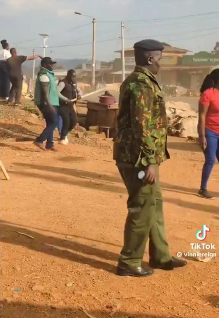ngugimartin67's tweet photo. Who is the officer in the photo protecting goons who were pelting stones towards Linda mwananchi convoys ? If parliament is independent enough ,this warrants an impeachment of a sitting president https://t.co/uT99T5ZL5Y