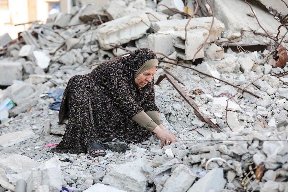 dn_osama_rabee's tweet photo. Two years after her home was destroyed, the elderly woman, Umm Atta Al-Nashash, continues to search through the rubble of her house, hoping to find the remains of her four sons, who were lost beneath the debris. https://t.co/lNRvyPhaMs