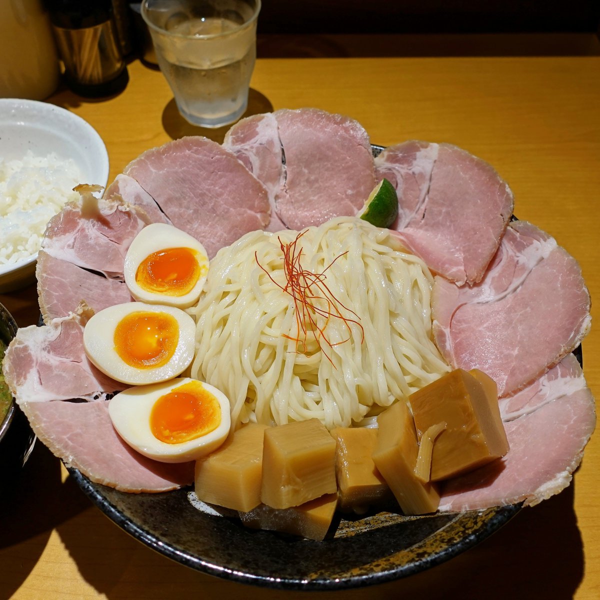agunesu_dejitar's tweet photo. らーめん鶴武者さん
ちゃーしゅーつけ麺(大盛)+めんま大盛+煮玉子･ごはん

昨日から導入された券売機で食券を購入してから着席♪
限定が続いてて超大好きなつけ麺を食べるのは約８ヶ月ぶりでした🤤

ﾂﾙﾂﾙでﾓﾁﾓﾁ食感の自家製麺は､そのまま食べると小麦の香りと旨味が最高で､酢橘を搾って食べても超絶品😋
魚介の濃厚な風味が抜群のｽｰﾌﾟとの相性も抜群で､丼に花が咲いたちゃーしゅー､煮玉子､めんまの具材も完璧で最高に旨い😍😍😍

ﾂﾔﾂﾔの「ごはん」もめちゃめちゃ美味しいですよ😋