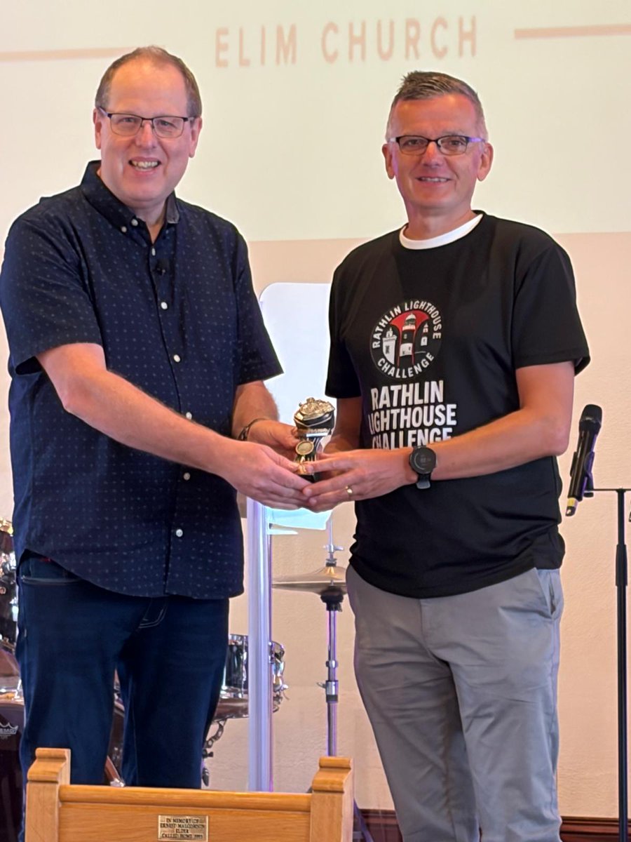 DC_Elim's tweet photo. I was delighted to be able to present a memento trophy to Pastor Roy and Ann Graham's son, Paul, who came over from Manchester to run the Rathlin Island Lighthouse Challenge run (25km) in aid of our church's extension fund. Paul completed the run in 2 hours and 14 minutes. https://t.co/8fhMG2Kref