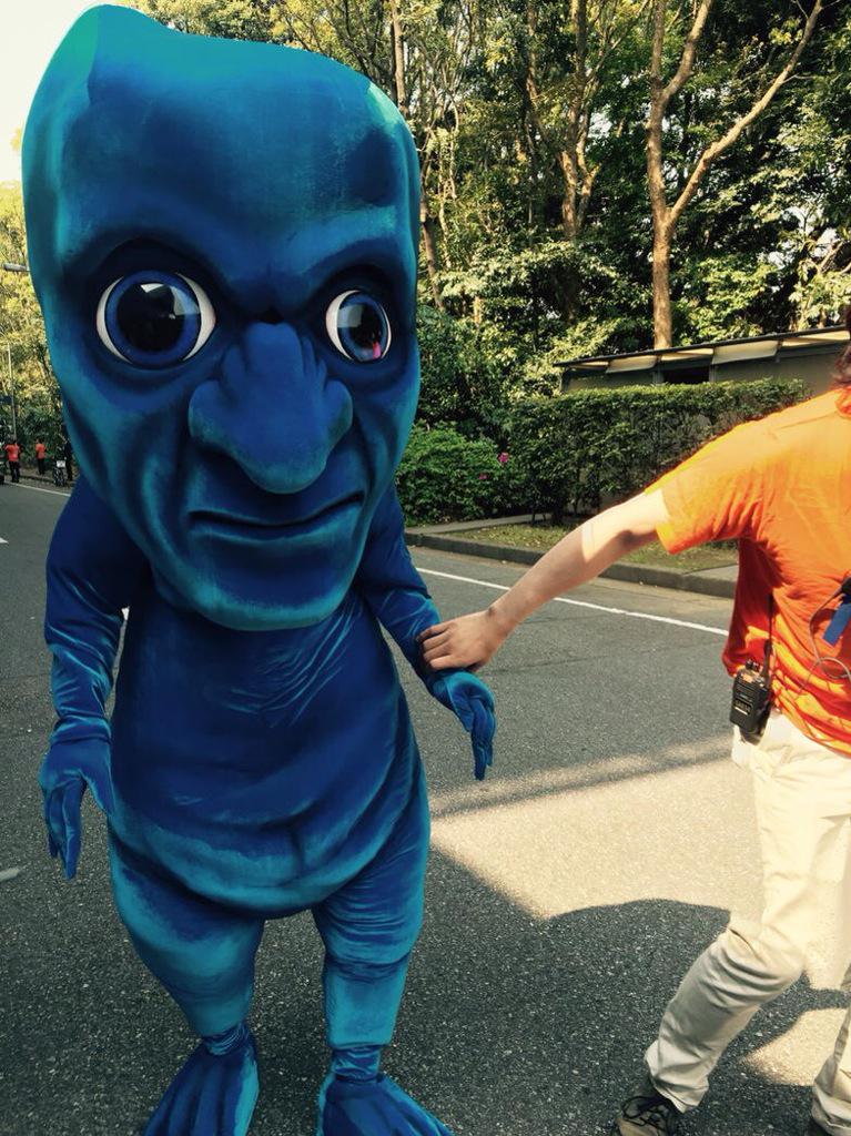 dailyoni's tweet photo. The Ao Oni mascot suit being guided by an assistant (2015) https://t.co/pudwSy59G3