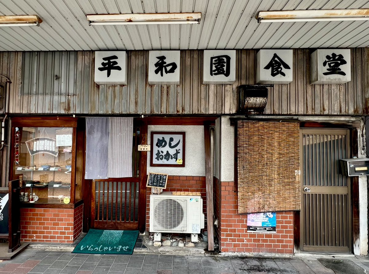 tolagen's tweet photo. 名古屋市柳原の平和園食堂へ。名城公園駅から徒歩10分程。無機質な街並みに忽然と。棚から焼なすを取ってビールを流し込む。注文でみそかつと玉子焼きと豚汁とごはんを。常連の年配の方々が慣れた様子でご飯を食べる。そこへ電子マネーは使えるか？にお断りされ帰るお姉さん。ゆったり時間が流れる。 https://t.co/1L7oAsg56G