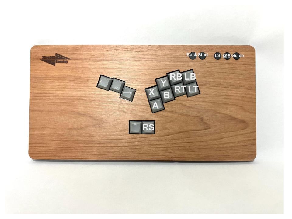 TogoHashibiroko's tweet photo. ここで新製品のお知らせ。
キーボード用キーキャップを採用したレバーレスコントローラー「カード」をベースとして、「四畳半たたみ」さん（@yjh_tatami）のオーダーを受けて製作した一品の量産型です。

たたみさんご本人は手が小さいとのことで、通常のレバーレスはボタンの間隔が空きすぎていて扱いにくかった事から、こちらのレバーレス製作依頼に至ったそうです。
アサダの木を利用した突板で赤みがかったボディが素敵な一品。幅広デザイン（幅345ｍｍ）のため、膝置きスタイルにも最適です。重さは約710g。今まで作った膝置きタイプの中で最軽量かもしれません。
キースイッチにはKailh Iris Purple miniを採用。ショートストロークで素早い入力が可能。静音性にも優れています。また、ホットスワップ対応しているので、スイッチの交換もできます。自分に最適なスイッチ探しも楽しいかも。
以上、よろしくお願いします！

#東郷アケコン製作記