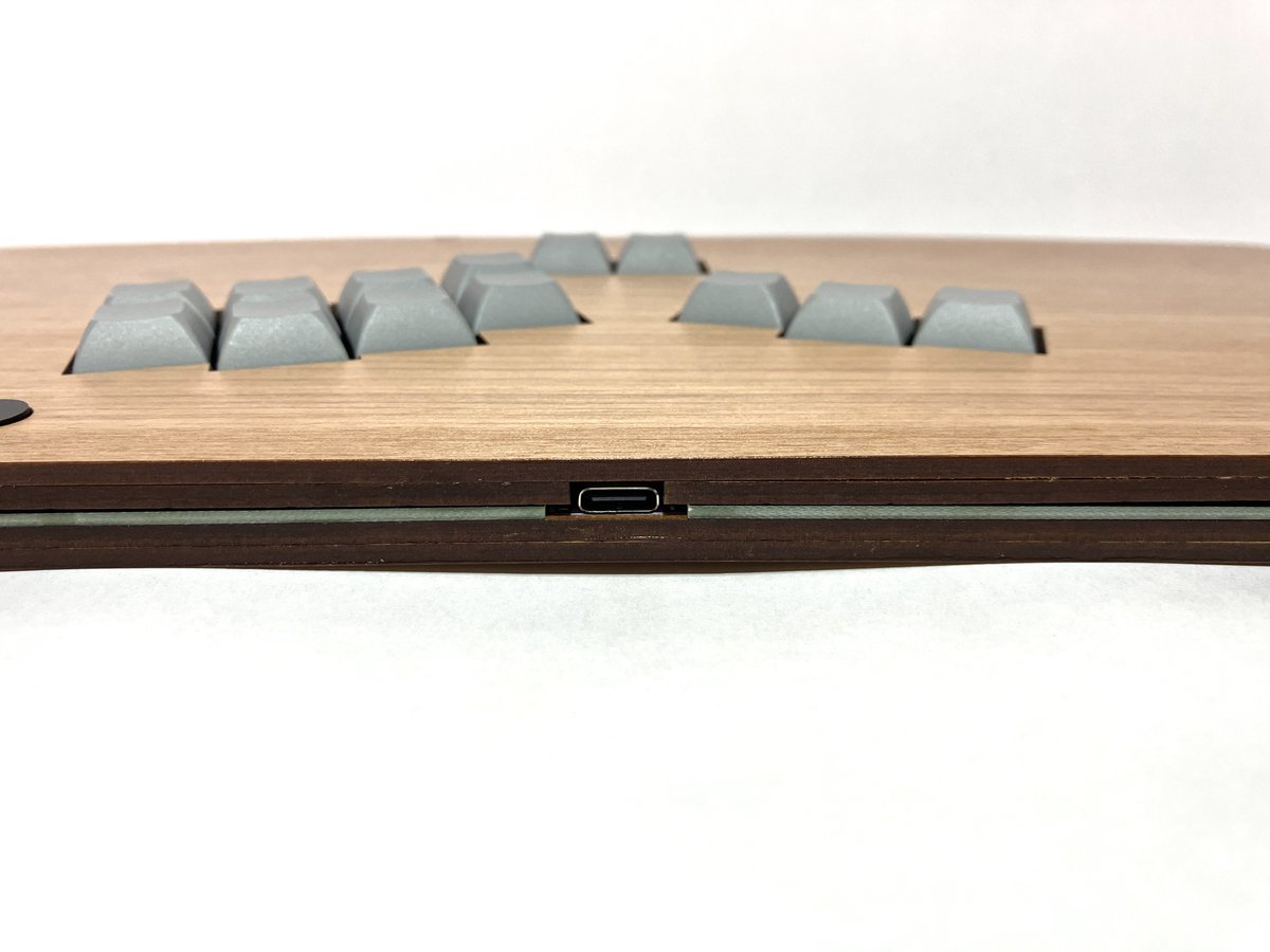 TogoHashibiroko's tweet photo. ここで新製品のお知らせ。
キーボード用キーキャップを採用したレバーレスコントローラー「カード」をベースとして、「四畳半たたみ」さん（@yjh_tatami）のオーダーを受けて製作した一品の量産型です。

たたみさんご本人は手が小さいとのことで、通常のレバーレスはボタンの間隔が空きすぎていて扱いにくかった事から、こちらのレバーレス製作依頼に至ったそうです。
アサダの木を利用した突板で赤みがかったボディが素敵な一品。幅広デザイン（幅345ｍｍ）のため、膝置きスタイルにも最適です。重さは約710g。今まで作った膝置きタイプの中で最軽量かもしれません。
キースイッチにはKailh Iris Purple miniを採用。ショートストロークで素早い入力が可能。静音性にも優れています。また、ホットスワップ対応しているので、スイッチの交換もできます。自分に最適なスイッチ探しも楽しいかも。
以上、よろしくお願いします！

#東郷アケコン製作記