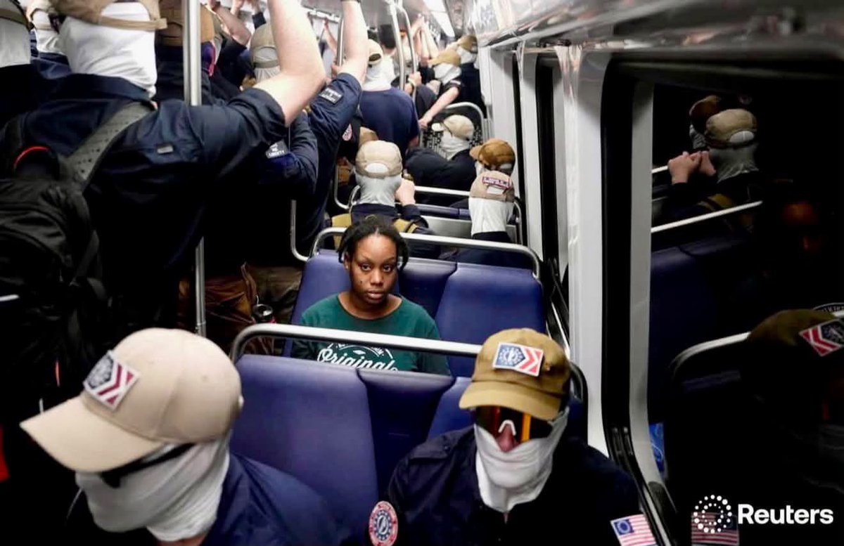 dasilvabenedita's tweet photo. Uma mulher negra sentada sozinha, cercada por supremacistas brancos mascarados, no dia em que os Estados Unidos celebravam 250 anos.

Essa foto vai ficar como símbolo: o ódio se expõe justamente quando tenta se esconder atrás de máscaras e bandeiras.

No meio disso tudo, a coragem de uma mulher negra que não recuou. Eu me vejo nela.

É o mesmo projeto que lutamos para derrotar aqui no Brasil. Essa luta não para! 
📸 @Reuters @orr_photo