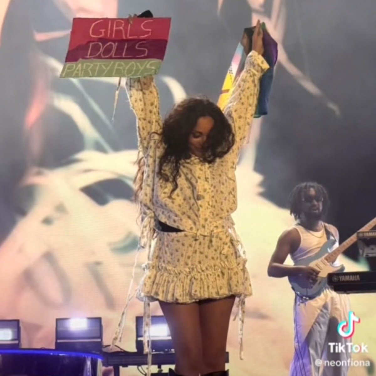 JADEtearoom's tweet photo. JADE holds up a Pride flag and a “GIRLS, DOLLS, PARTY BOYS” sign from fans while performing her LGBTQ+ anthem ‘Church’ in Poland, where same-sex marriage is banned, no specific hate crime laws exist to protect LGBTQ+ people, and “LGBT Ideology Free Zones” were only abolished in 2025 due to severe retaliatory funding cuts from the EU