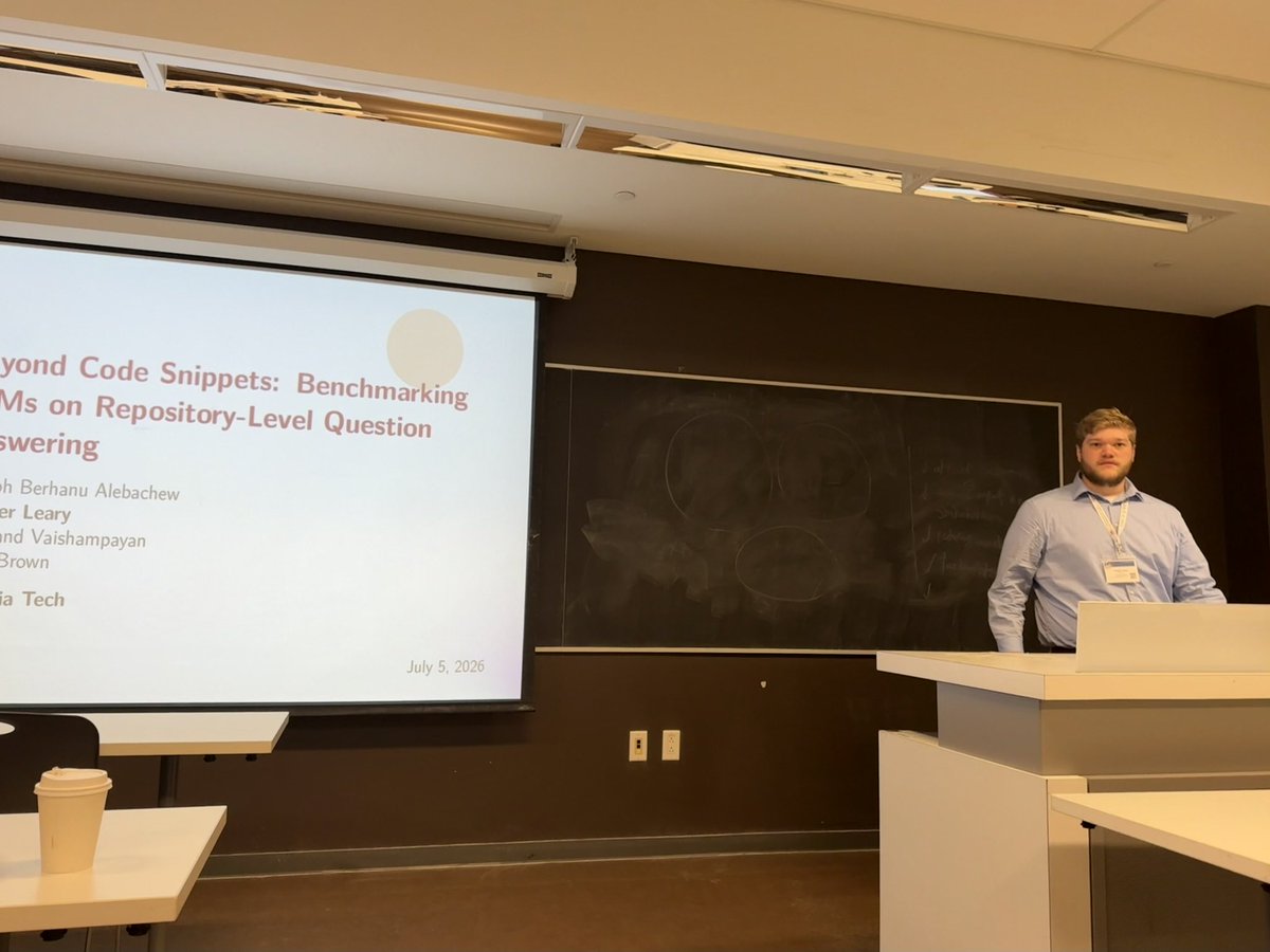 promise_conf's tweet photo. 📚  Hunter Leary presents "Beyond Code  Snippets" — benchmarking LLMs on repository-level QA. With Yoseph Berhanu Alebachew,  Swanand Vaishampayan &amp; Chris Brown. #PROMISE2026  #FSE2026 #PROMISE26 #FSE26 https://t.co/xBO9L7ahVO