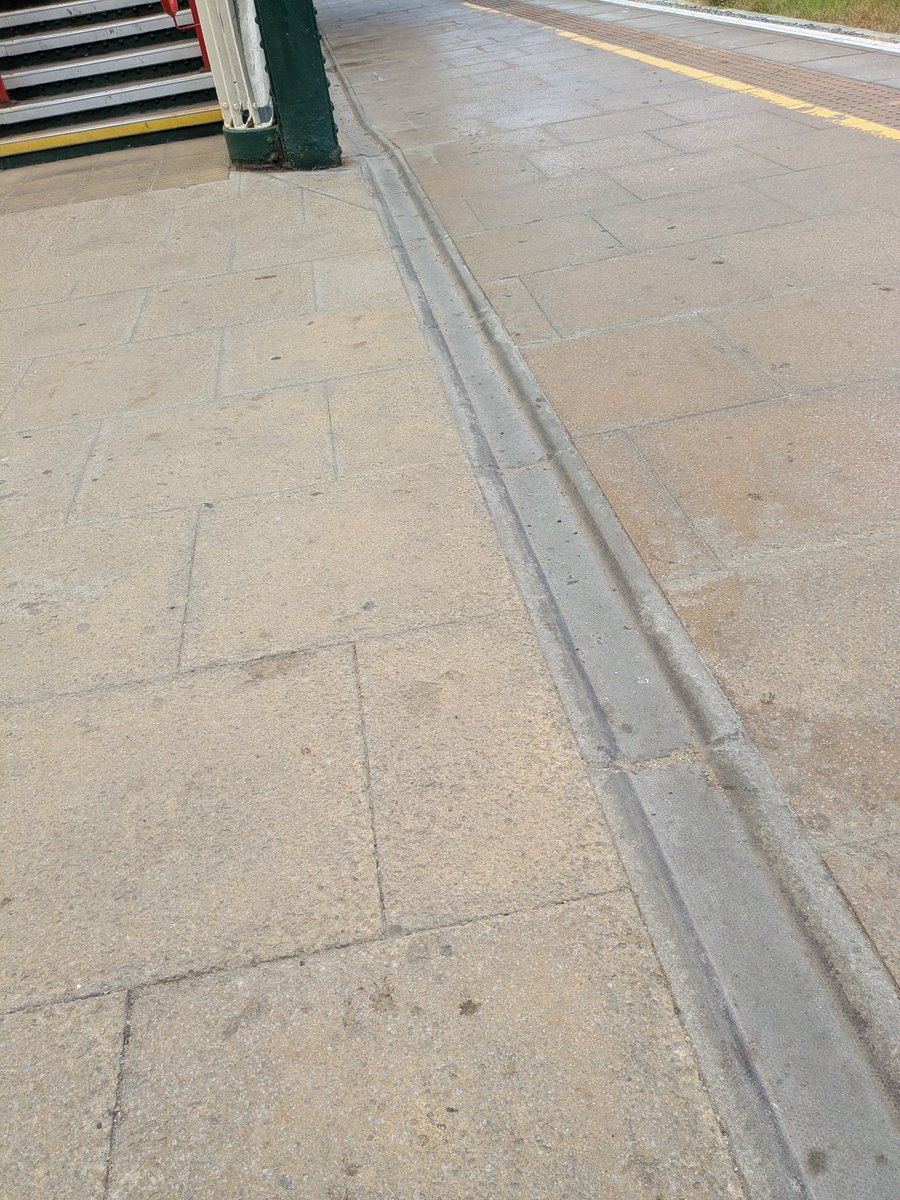 rob_milky's tweet photo. Major trip hazard flagged at Wrexham General! Completely open drainage channels camouflaged right at the base of the footbridge steps on Platforms 2 &amp; 4. Perfect for catching long canes &amp; collecting slippery debris. High-contrast grates needed now @tfwrail! (Ref: 1000050010.jpg) https://t.co/CYX5R6LyHN