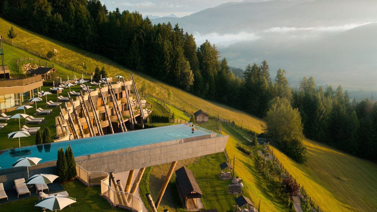 Must_Visit_Net's tweet photo. Hotels with the Most Spectacular Views in the World
Today, we present Hotel Hubertus in South Tyrol, a place that undisputedly offers one of the most spectacular views in the entire world.
Nestled in the heart of the breathtaking Dolomites in northern Italy, this architectural masterpiece redefines the concept of a room with a view. What truly sets Hotel Hubertus apart—and makes it a viral sensation worldwide—is its legendary Sky Pool. Suspended 12 meters above the ground on massive larch columns, this 25-meter infinity pool stretches out into the open air like a floating glass bridge. With a glass bottom section, it gives you the surreal sensation of floating weightlessly between the earth and the sky.
Whether you are swimming in the heated waters of the Sky Pool or relaxing on the panoramic terraces, you are treated to a jaw-dropping, 360-degree unobstructed vista. The dramatic peaks of the Dolomites, lush alpine meadows, and the sweeping Valdaora valley unfold right before your eyes. In the winter, it transforms into a snowy wonderland; in the summer, a vibrant green paradise.
Combined with its striking modern design that blends seamlessly into the alpine landscape, Hotel Hubertus isn't just a place to stay—it is a sensory escape where nature and luxury collide in the most visually stunning way imaginable.
#HotelHubertus #SouthTyrol #Dolomites #ItalyTravel #InfinityPool #SkyPool #BeautifulDestinations #Wanderlust #LuxuryTravel #SpectacularViews #TravelGoals #Alps #HotelWithAView