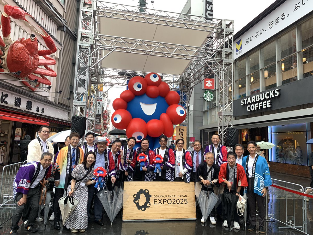dotonbori_jp's tweet photo. 万博の #いらっしゃいミャクミャク が道頓堀へ！

吉村洋文大阪府知事、横山英幸大阪市長らによる除幕式が執り行われました。

【ミャクミャクモニュメント】
📍道頓堀商店街 かに道楽本店前（大阪市中央区道頓堀1丁目8）

📅2026年7月6日（月）～8月31日（月）（予定）

#みゃくみゃく道頓堀 https://t.co/CQDdwCYnrR