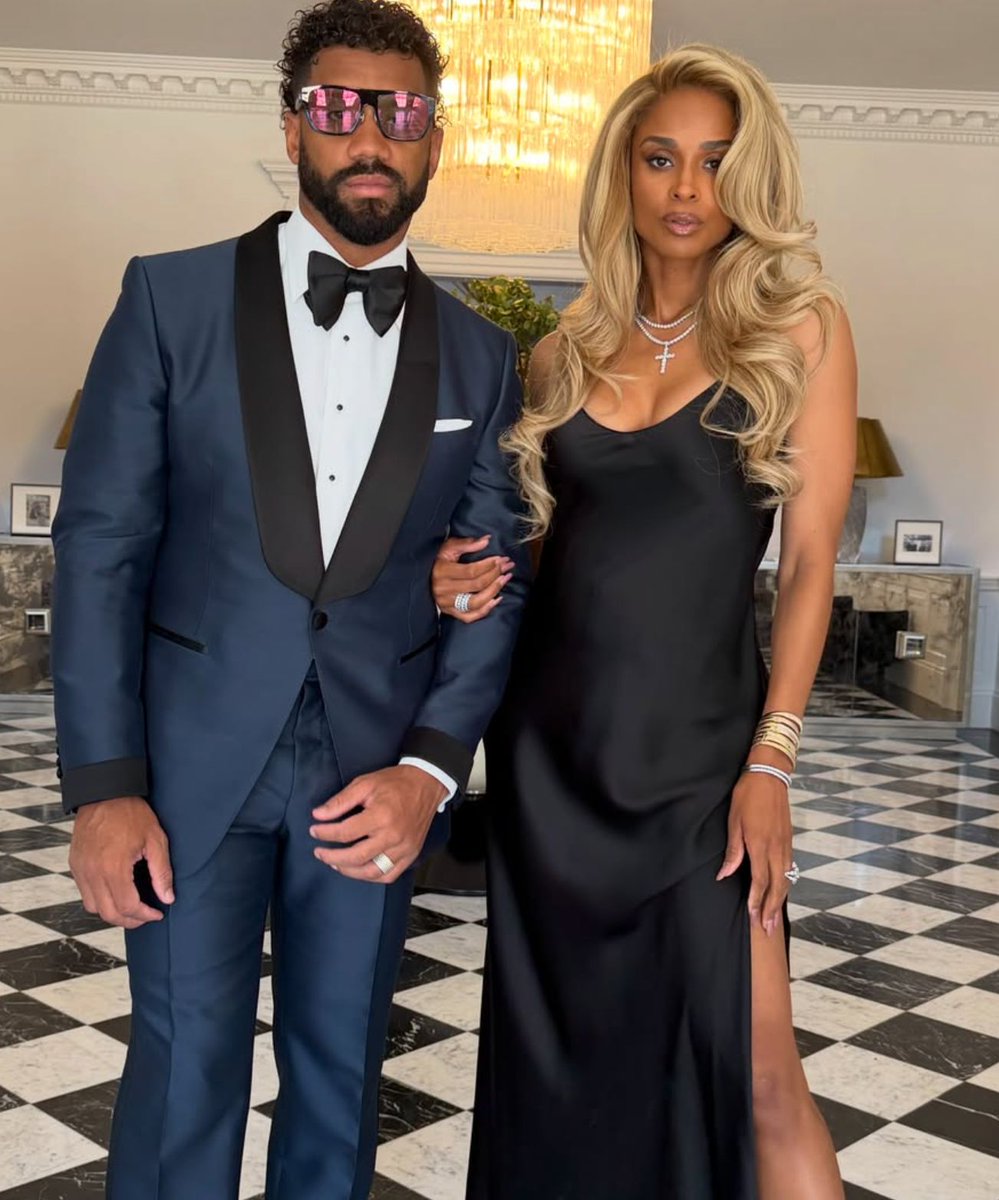 glittermagazine's tweet photo. Leave it to Ciara and Russell Wilson to turn a checkerboard floor into a runway. 🏁✨ With a knowing "A NighTT For Lovers 🖤" caption of their own, it's safe to assume the pair were among the lucky names on Taylor and Travis's list — and darling, they came dressed. 🥂 Ciara poured herself into a liquid-black slip gown with a thigh-high slit and stacked gold cuffs, while Russell kept it sharp in a midnight-blue tux with satin peak lapels. Two decades of red carpets between them and they still set the standard for a power-couple entrance. 💫 Him or her — who wore it better? 👀 We're calling it a tie.

#Ciara #RussellWilson #TaylorSwift #TravisKelce #CelebrityStyle #PowerCouple #Tayvis #GlitterMagazine
