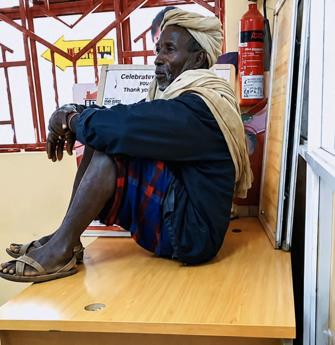guru_voke's tweet photo. This elderly man reportedly visited an Equity Bank branch in Marsabit and found every seat occupied. Instead of standing or complaining, he climbed onto an unused cabinet and sat there comfortably while waiting to be served. 😂 https://t.co/DkUYfloQSH
